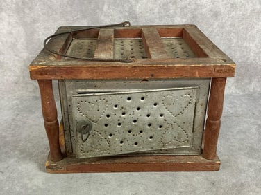 Mid 1800s heater. Made of punched metal with wooden case, often called a “foot stove??. Includes