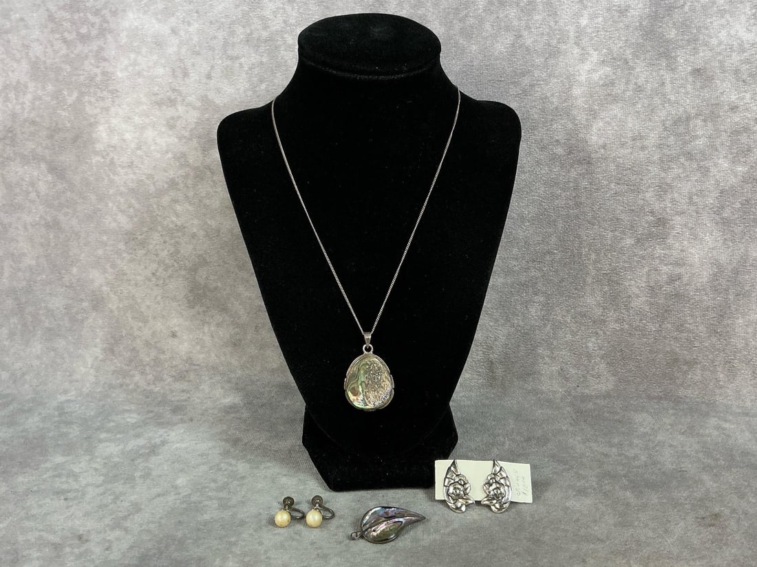 Sterling silver abalone pendant on a sterling chain, abalone set in sterling brooch, and two pairs: Sterling silver abalone pendant on a sterling chain, abalone set in sterling brooch, and two pairs of screw back earrings. One pair are faux pearls. All marked Sterling or 925. Total weight 0.69 ozt.
