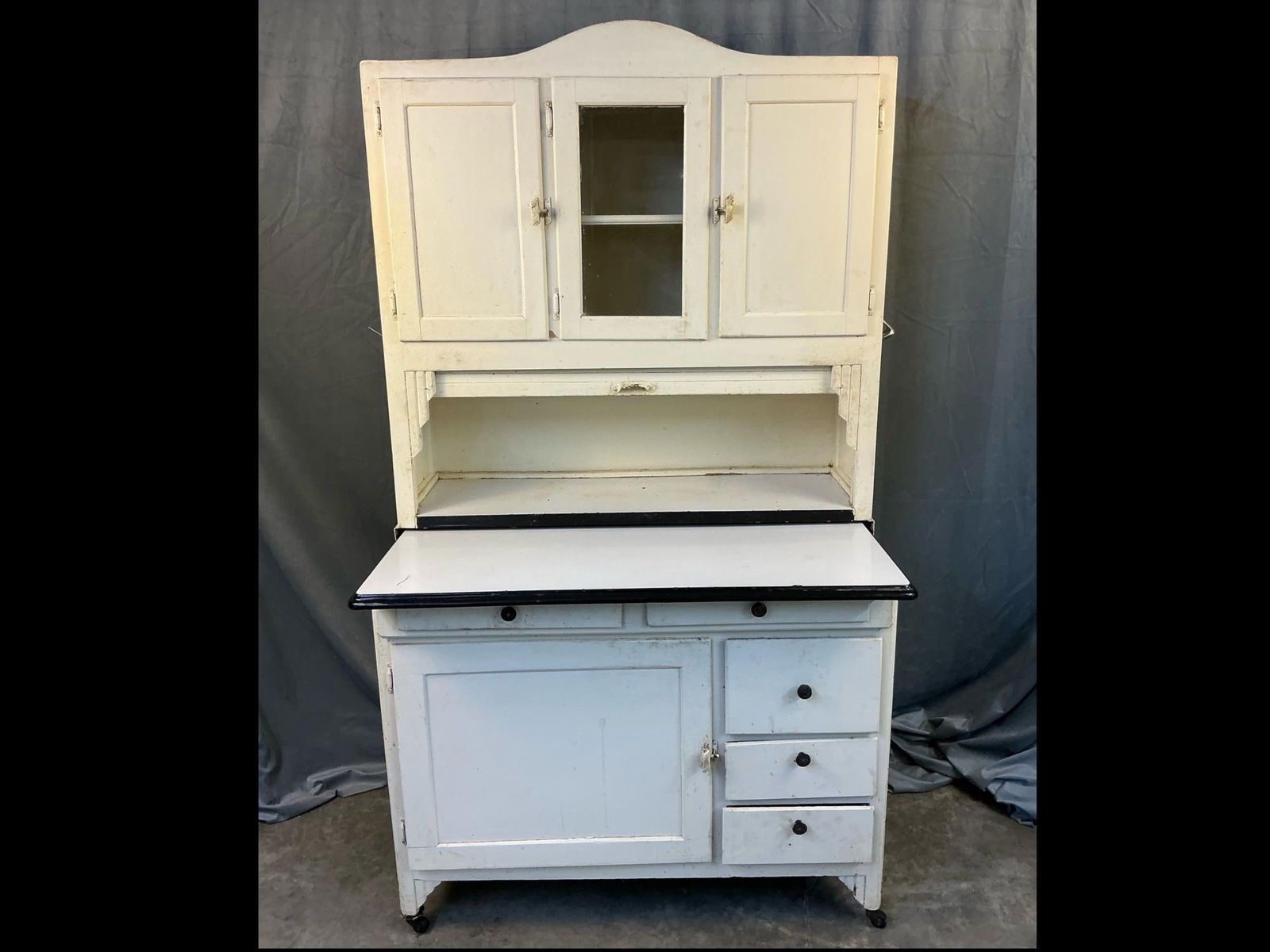 1930's "Sellers Mastercraft" Hoosier cabinet with old white repainted surface, porcelain top, flour: 1930's "Sellers Mastercraft" Hoosier cabinet with old white repainted surface, porcelain top, flour bin, castors, and a retractable shelf in the lower cupboard. Retractable door nailed open. Some back
