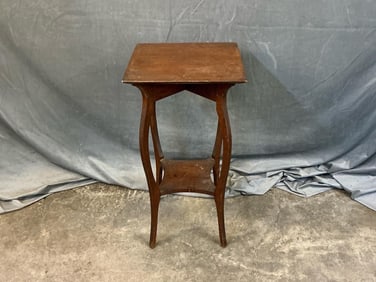 Early 20th century oak stand with saber legs. Original stain finish. Good condition. Measures 16