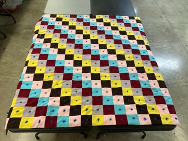 1970s machine stitched and hand tied quilt. Good condition, some tied knots are missing. Measures 70