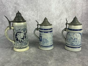 Early 20th century lot of three salt glazed and cobalt decorated German beer steins with pewter lids