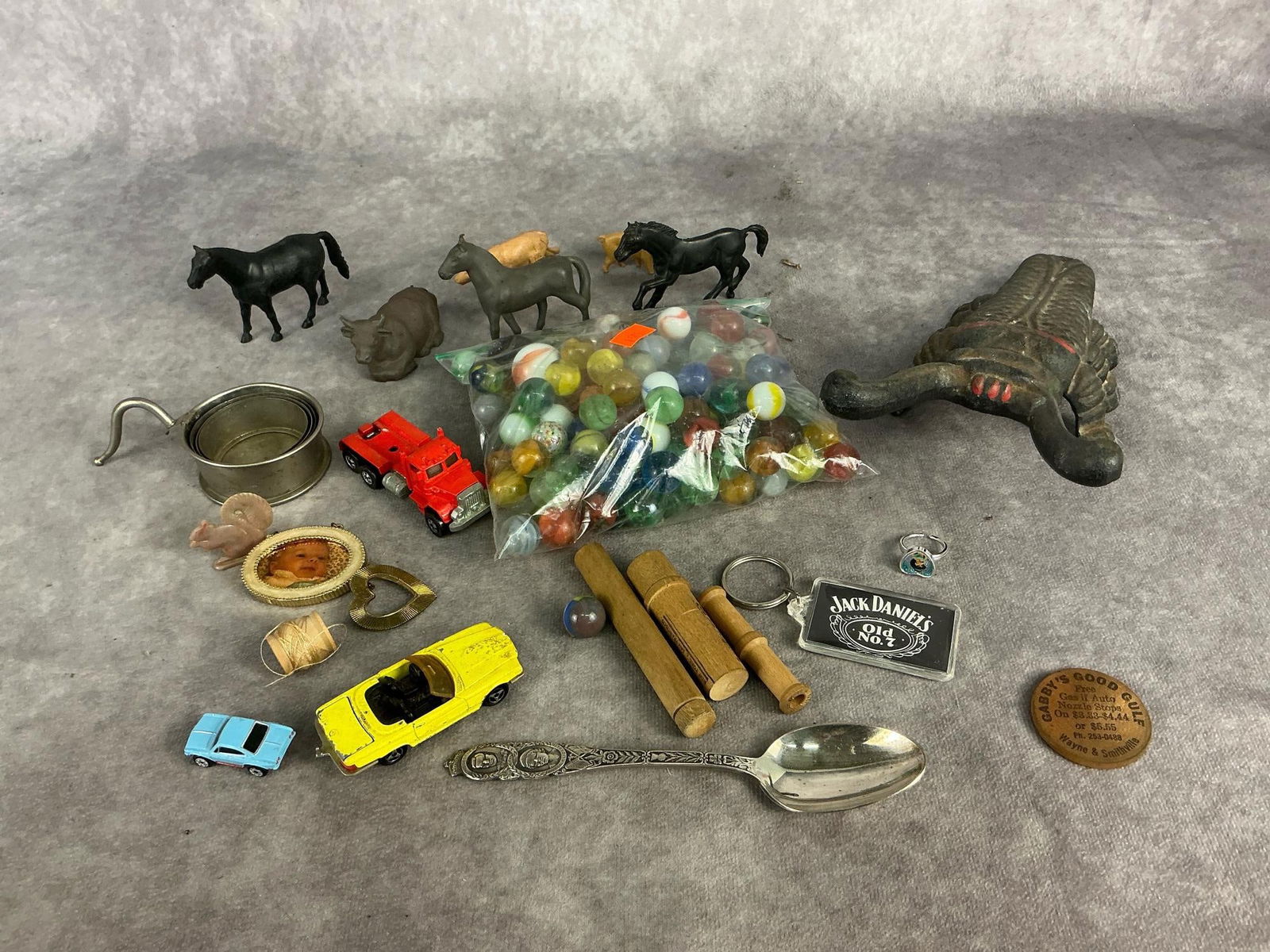 20th century cast iron beetle bug boot jack, marbles, hot wheel, plastic farm animals, needle cases,: 20th century cast iron beetle bug boot jack, marbles, hot wheel, plastic farm animals, needle cases, costume jewelry, Jack Daniel's key ring, souvenir spoon and miscellaneous small items. Boot jack ma