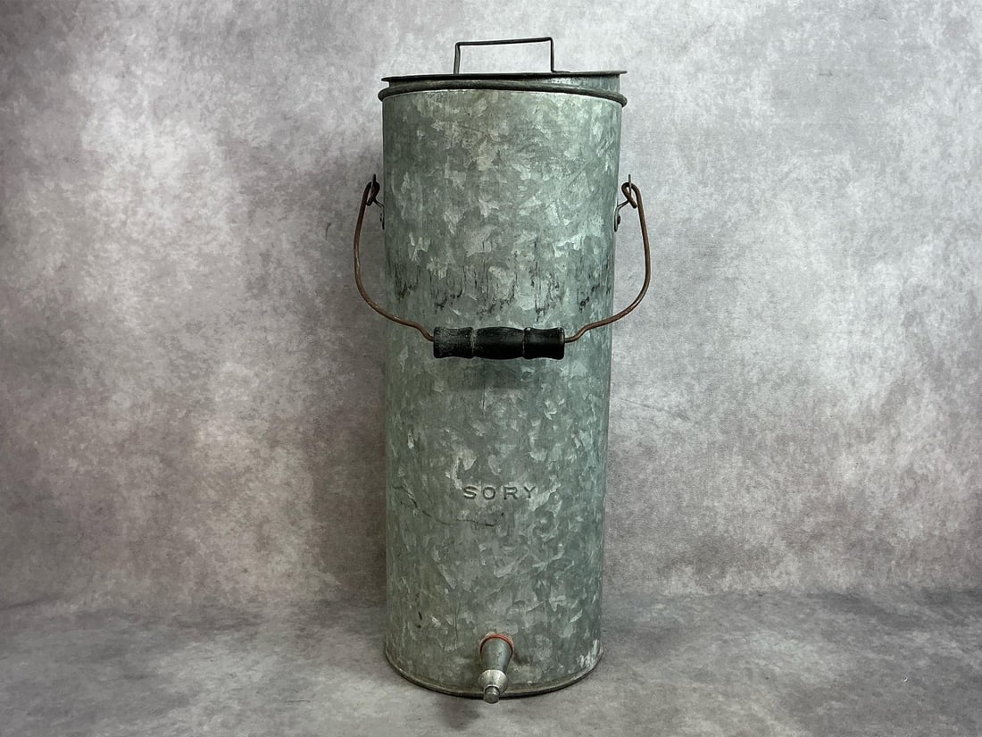 1920's water cooler. Galvanized water cooler by Sory with wooden handle and lid. Rust present on: 1920's water cooler. Galvanized water cooler by Sory with wooden handle and lid. Rust present on handle, otherwise In good condition. Measures 8” in diameter x 20.5 inches tall.