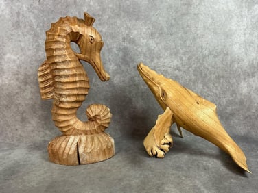 Two modern wooden sculptures. Hand carved humpback whale and carved seahorse. Wooden base on