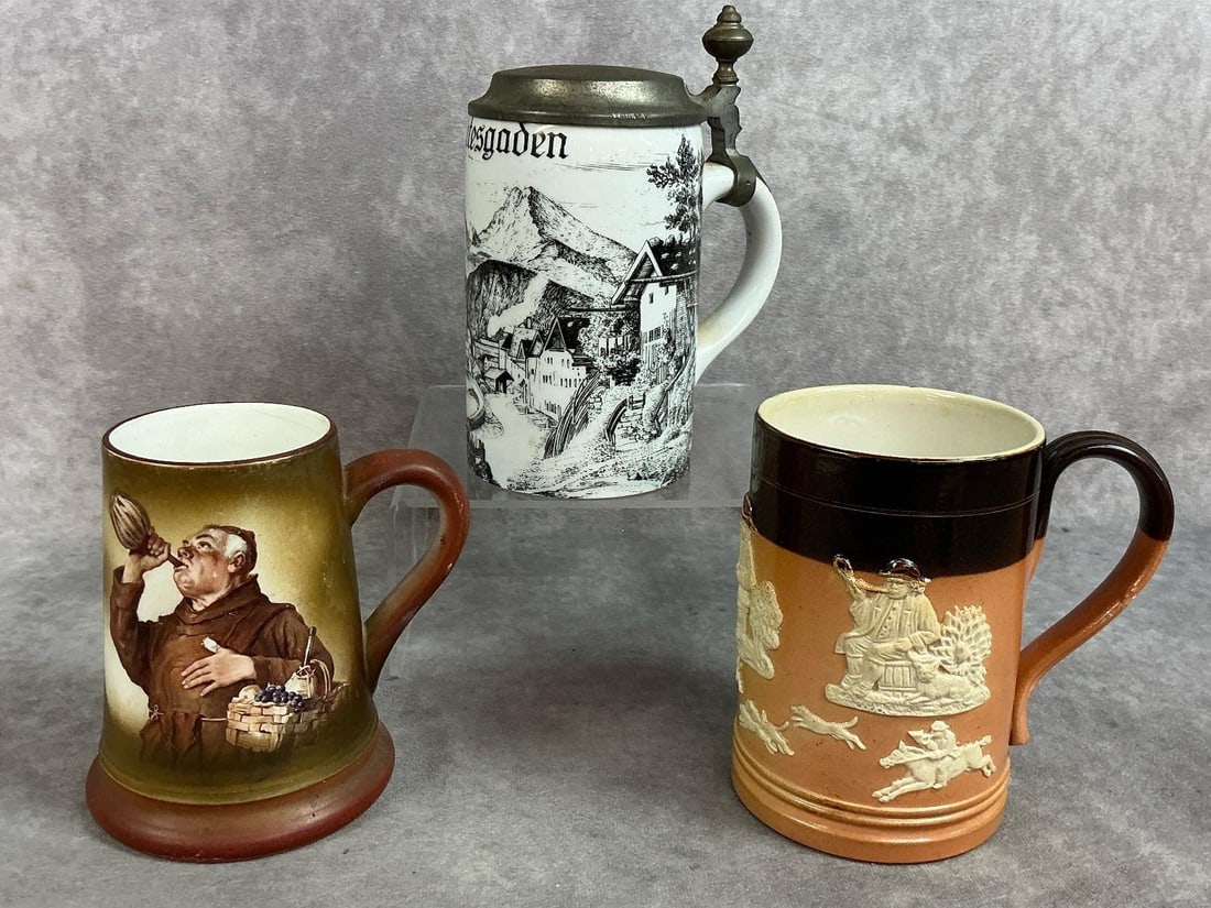 Three early 1900s mugs and stein. German Berchtesgaden ceramic stein with pewter lid. Mugs are: Three early 1900s mugs and stein. German Berchtesgaden ceramic stein with pewter lid. Mugs are English Royal Doulton Lambeth stoneware mug with raised relief decoration and a Friar Mug from Trenton, N