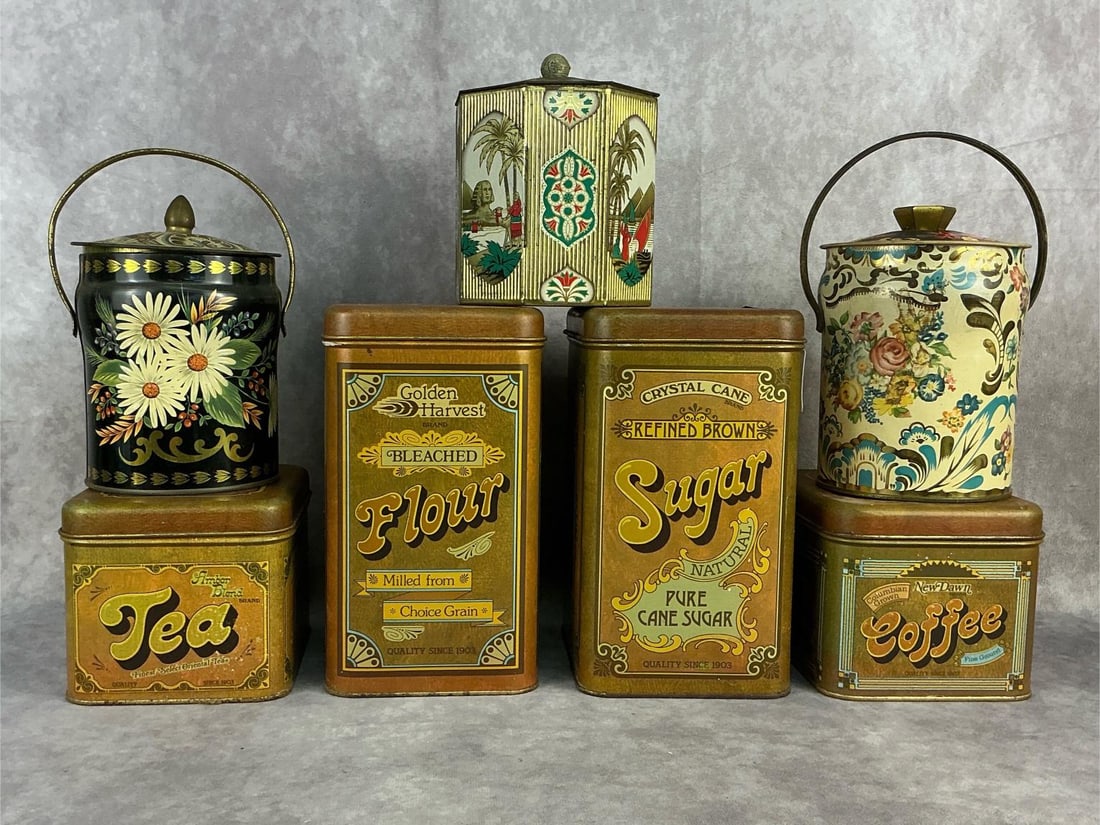 Group of seven 1960's - 1970's tin food storage containers. Two large sugar and flour containers: Group of seven 1960's - 1970's tin food storage containers. Two large sugar and flour containers with two matching smaller tea and coffee containers. Three additional decorative tea and biscuit/cookie