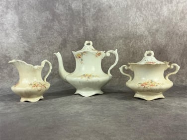 Circa 1900 three piece Limoge tea service with teapot , creamer, and sugar. Small chip to sugar rim,