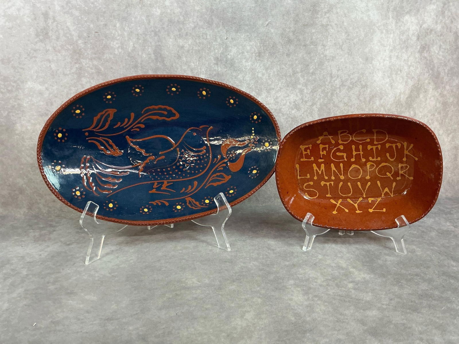 1980s Foltz Pottery Redware slip glaze platter and alphabet bowl. Both are signed by the artist and: 1980s Foltz Pottery Redware slip glaze platter and alphabet bowl. Both are signed by the artist and in good condition. Platter is 14.25 inches wide x 9 x 2 inches tall.