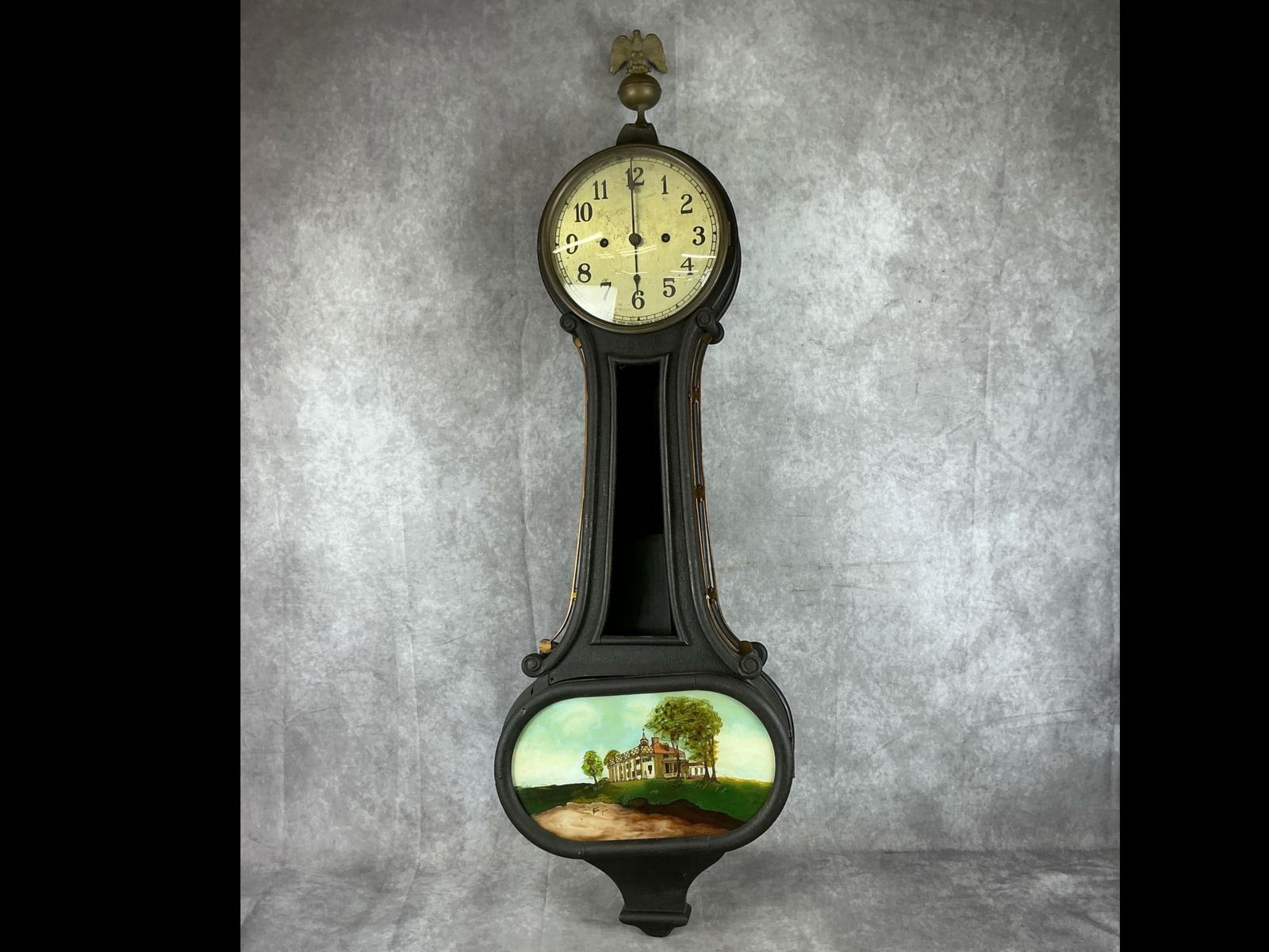 New Haven "Wilson" Banjo Wall Clock: 1920's New Haven "Wilson" Banjo Clock, New Haven, Connecticut. Mahogany case with brass side arms and eagle finial, with Reverse painting on glass of George Washington's Mount Vernon. Fair condition w