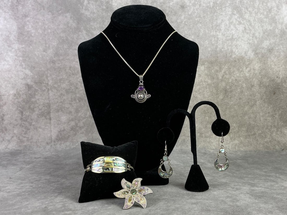 Abalone Shell Jewelry: Abalone shell earrings, cuff, and brooch, also included sterling silver amethyst necklace. All in good condition, brooch and necklace are stamped, oxidation present. Total weight of stamped sterling i