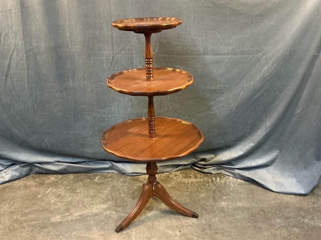 Dumbwaiter: Mid-20th century three tier mahogany Regency/Duncan Phyfe style dumbwaiter with dished tops and fluted legs. Good condition. Measures 21.25 inches wide in diameter x 41.5 inches tall.