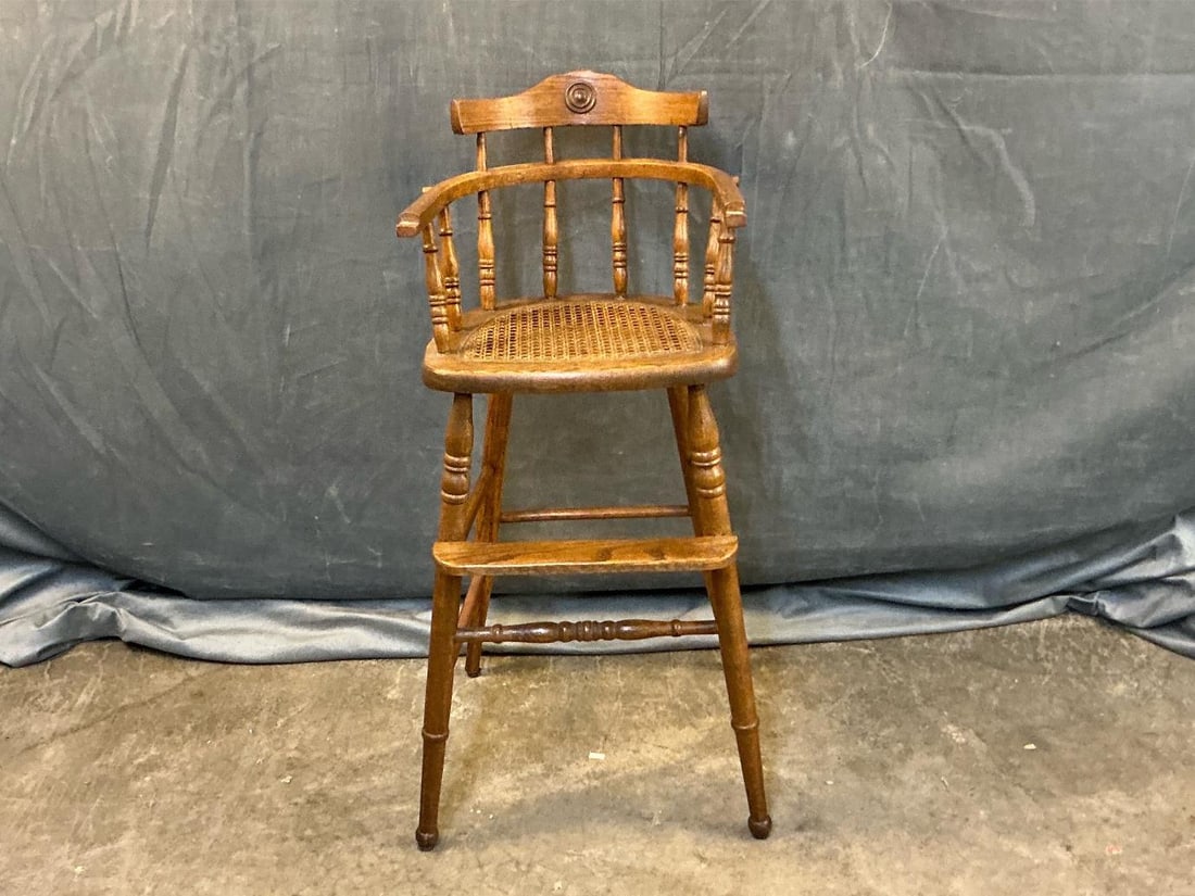 High Chair: Late 19th century - early 20th century child's oak high chair. Cane seat. Missing pull down tray. Measures 13.5 inches wide x 16 x 32.75 inches tall.