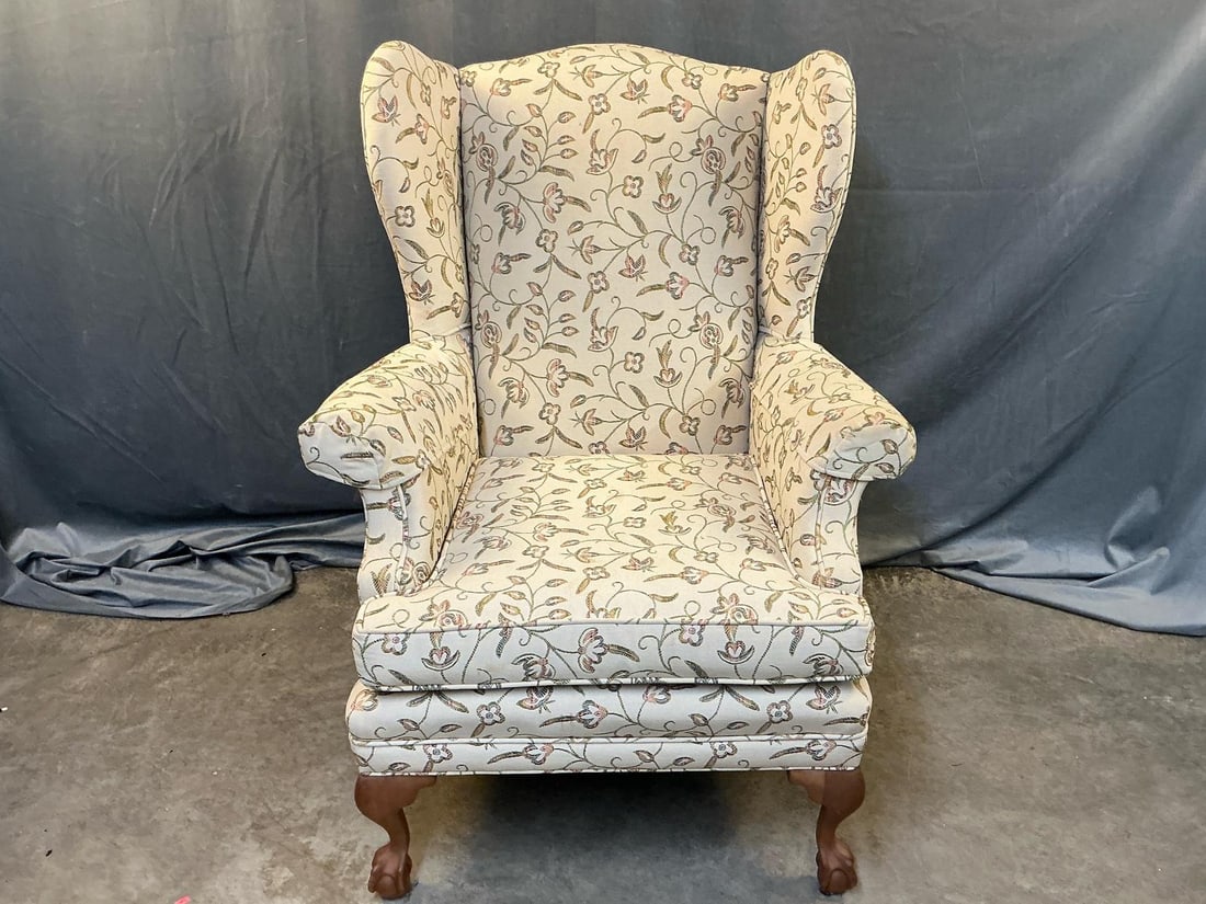 Wingback Chippendale Armchair: Late 20th century Chippendale style upholstered wingback chair. Ball and claw feet. Repair to broken back leg. Cushion has soiled spot to one side, otherwise good condition. Measures 27 inches wide x