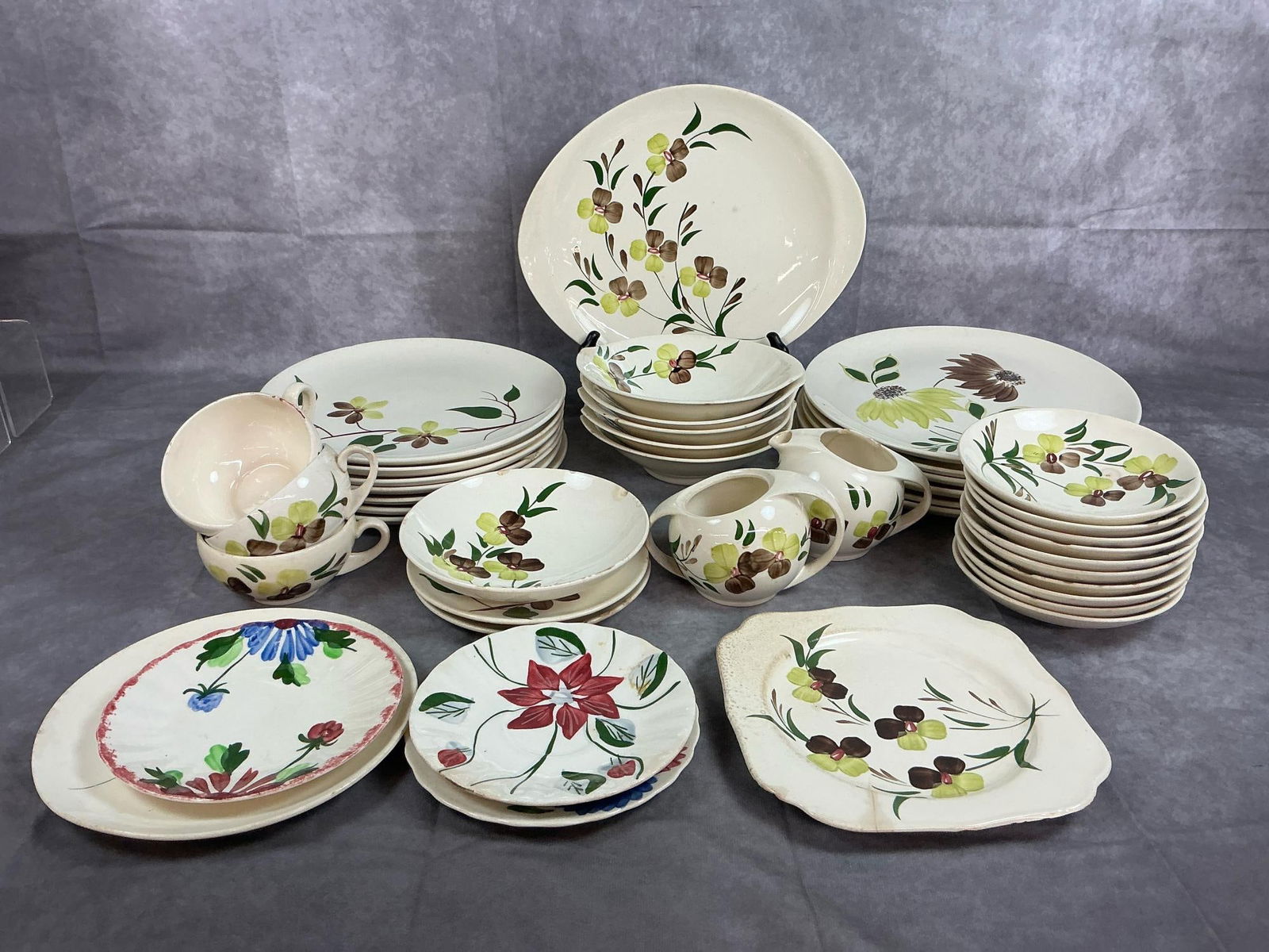 Blue Ridge Southern Pottery: Forty two assorted Blue Ridge dishes from the 1960s. Includes Sunny Spray pattern dinner plates, saucers, cups, bowls and more. Four saucers are other patterns. Dishes have chips and some discoloratio