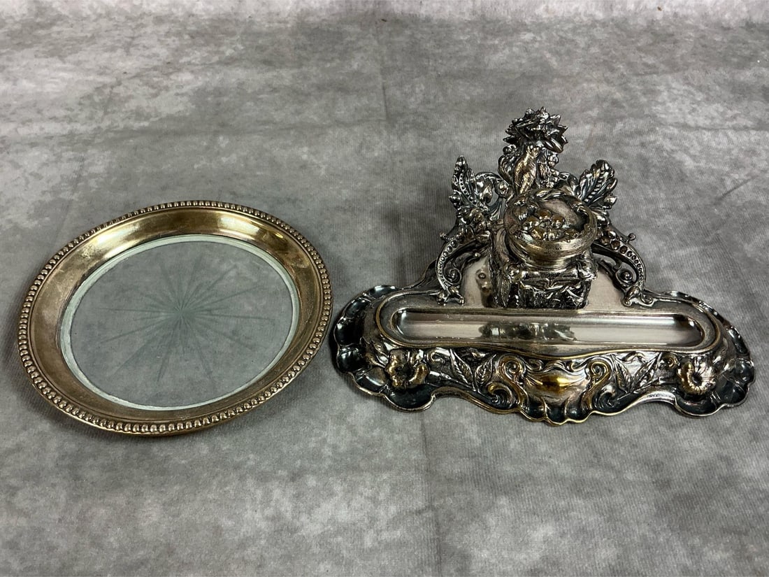 Silver Plated Ink & Pen Rest & Coaster: Early to mid 1900s ink holder and coaster. Silver plated antique Art Nouveau ink and pen holder. Silver plated with glass center coaster. Both in good condition. Ink holder measures 7.5 inches in widt