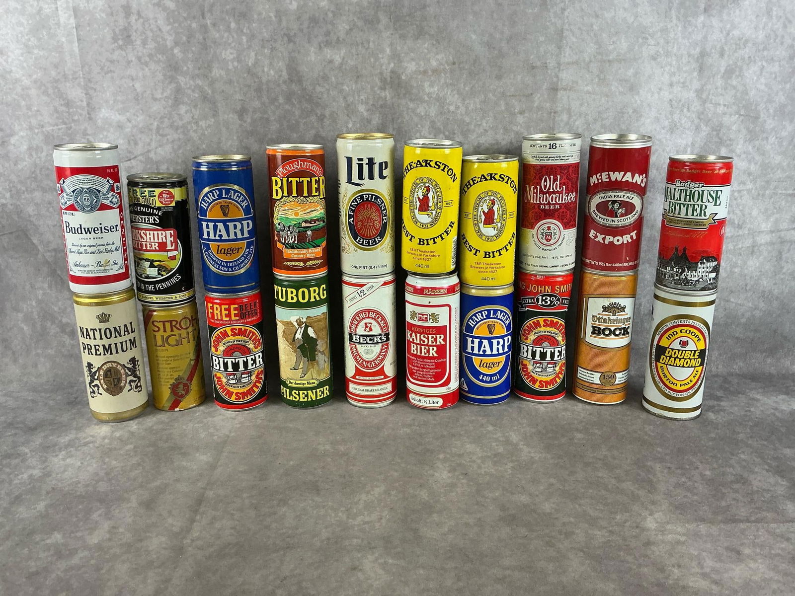 Collectible Beer Cans: An assortment of 1970's-1980's pull tab top collectible vintage domestic and imported beer cans. Twenty total beer cans. Collection includes Double Diamond, McEwan's, John Smith's, Budweiser, Harp, Ka
