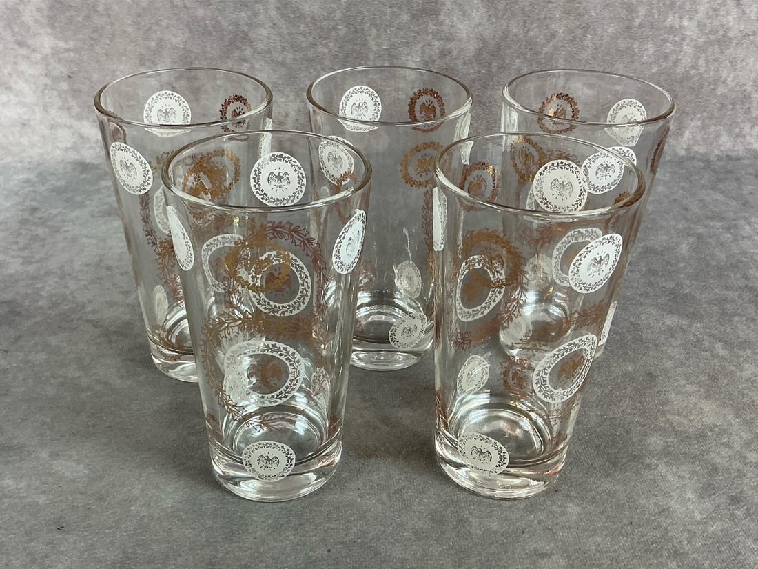 Golden Eagle Glasses: Five mid century drinking glasses. Golden Eagle or Patriotic glasses by G Reeves, with white and gold accents. In good condition. Measures 2.75 inches diameter at top x 5 inches tall.