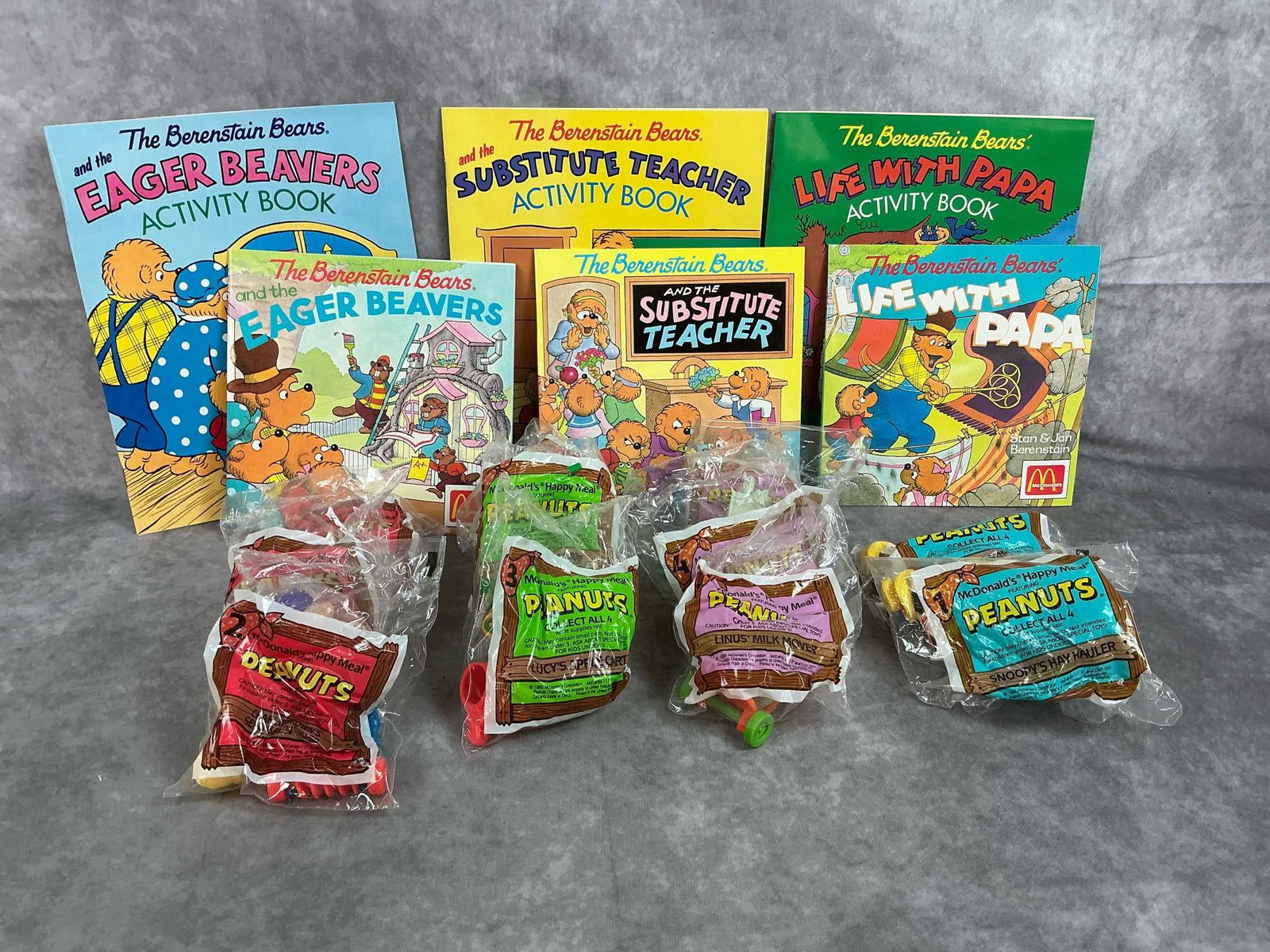 McDonalds Peanuts Toys & Berenstain Bears Books: Seventeen 1989-1990 toys and books. Eleven Peanuts Farm toys still in original packaging. Six Berenstain Bears activity or storybooks. All in good condition. Activity book measures 8 inches wide x 10