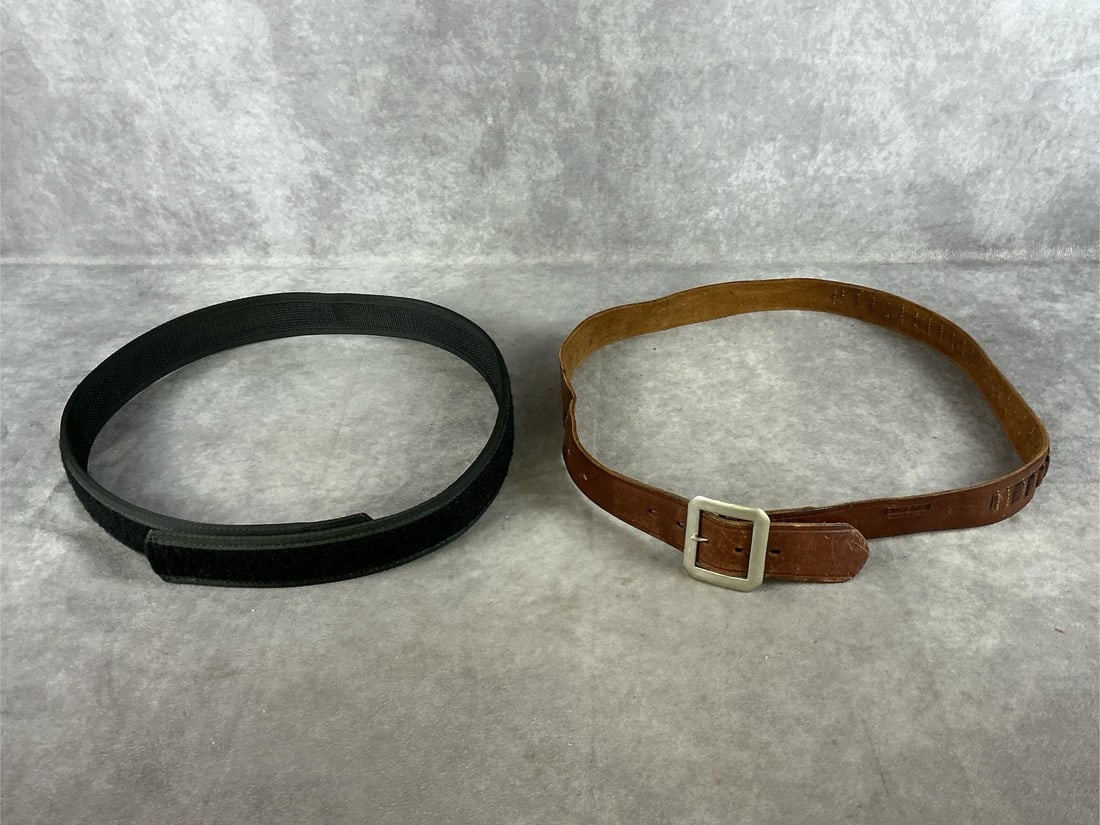 Bucheimer and Uncle Mikes Sidekick Gun Belts.: 1 lot two items. Brown leather and black synthetic belts. Both in good condition. Measure 43 inches long X 1.5 inches wide.