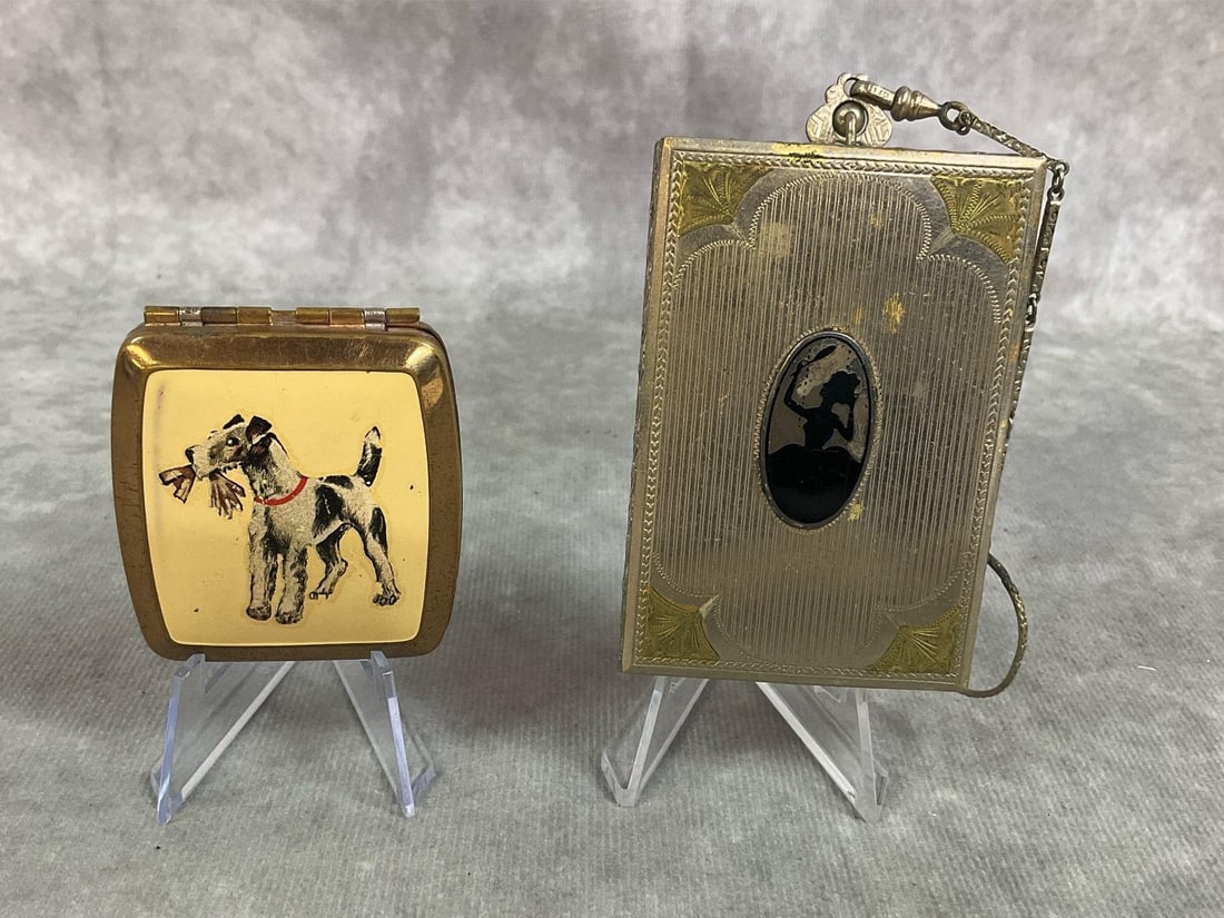 Vintage Ladies Compacts: Two early 1900s compacts. Metal compact dance purse or chatelaine compact with chain, decorated with silhouette of a lady. Gold tone and enamel powder compact with fox terrier. Some scratches and