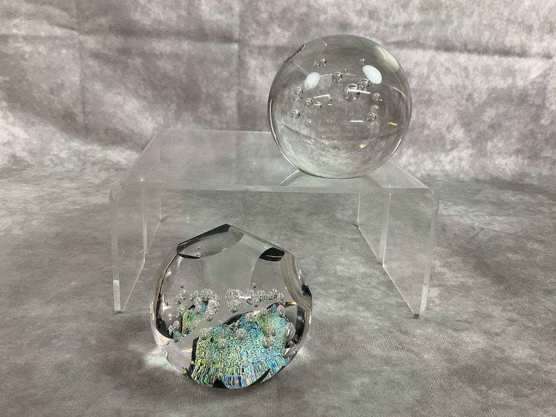 Art Glass Paperweights: Two mid century modern paperweights. Bohemia crystal clear with controlled bubbles paper weight. And a flat cut design sphere with sparkling depths signed by Bending. Both in good condition.
