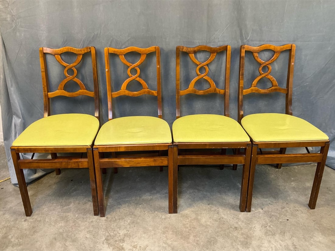 MCM Stakmore Chairs: 1930's - 1950's vintage set of four Stakmore figured maple folding chairs with light green vinyl seats. Original Stakmore paper label to three chairs with partial label to one - "Stakmore Trade Mark