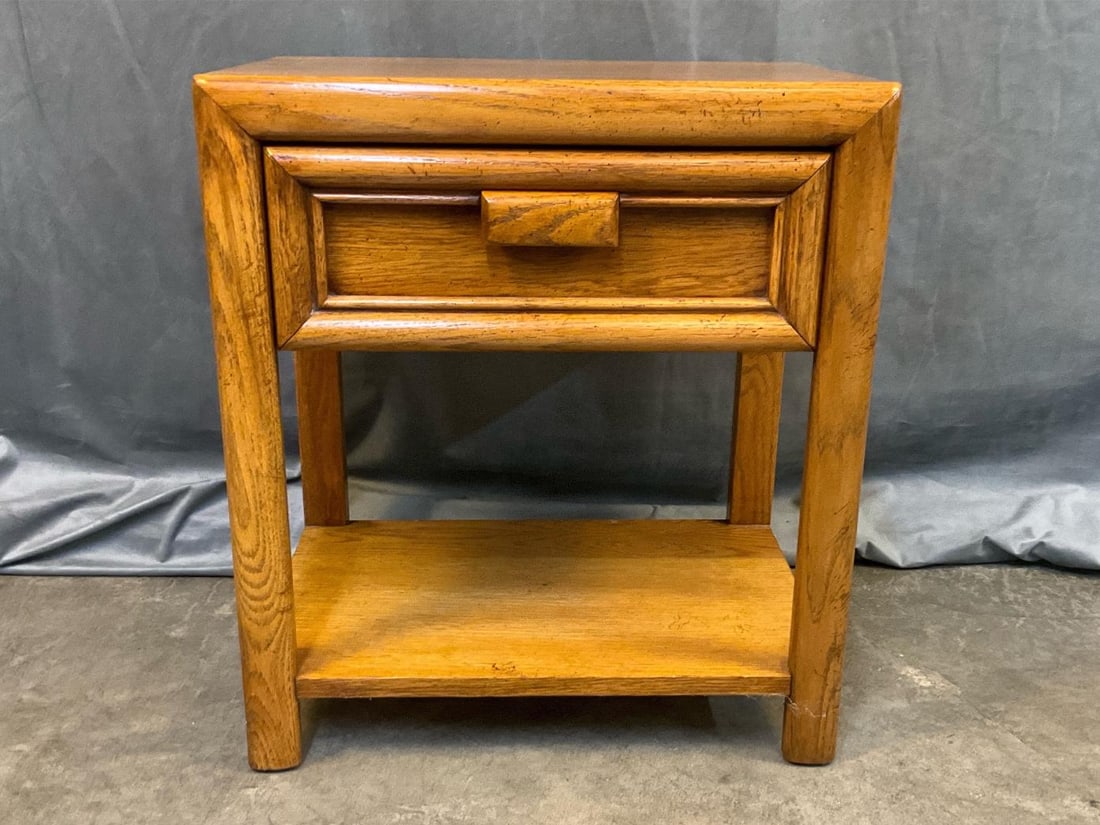 MCM Table: MCM circa 1970 oak finish side table with one drawer and lower shelf. Good condition. Measures 20 inches wide x 15 x 22 inches tall.