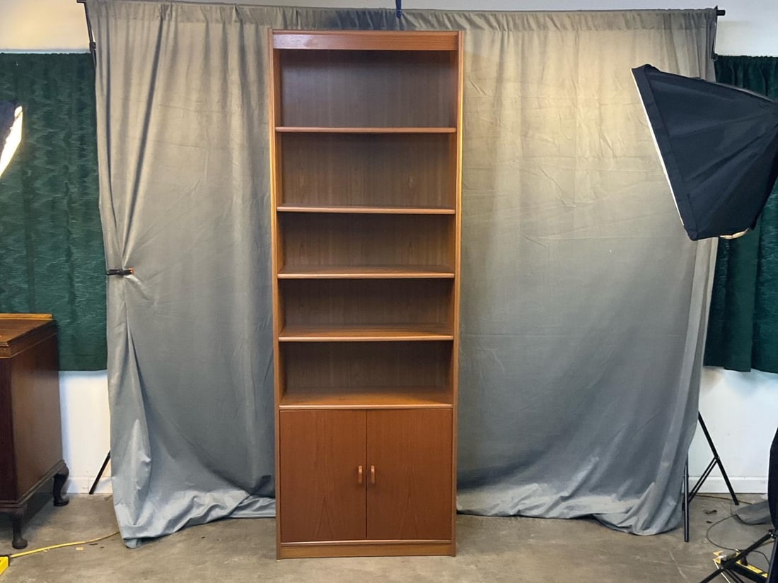 MCM Bookcase: MCM circa 1960's Danish Modern teak bookcase with five shelves total, four adjustable with two door cupboard storage area below. Marked "Made in Denmark" stamp on the back. Good condition. Measures