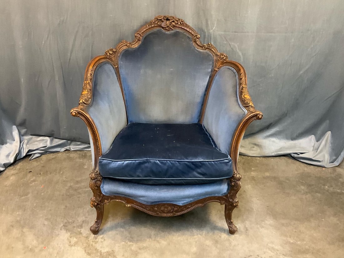 Rococo Chair: Late 19th century Victorian Rococo Revival upholstered carved walnut armchair. Carved horn and violin to crest rail with carved foliate decoration to arms and legs. Fabric soiled and UV faded,