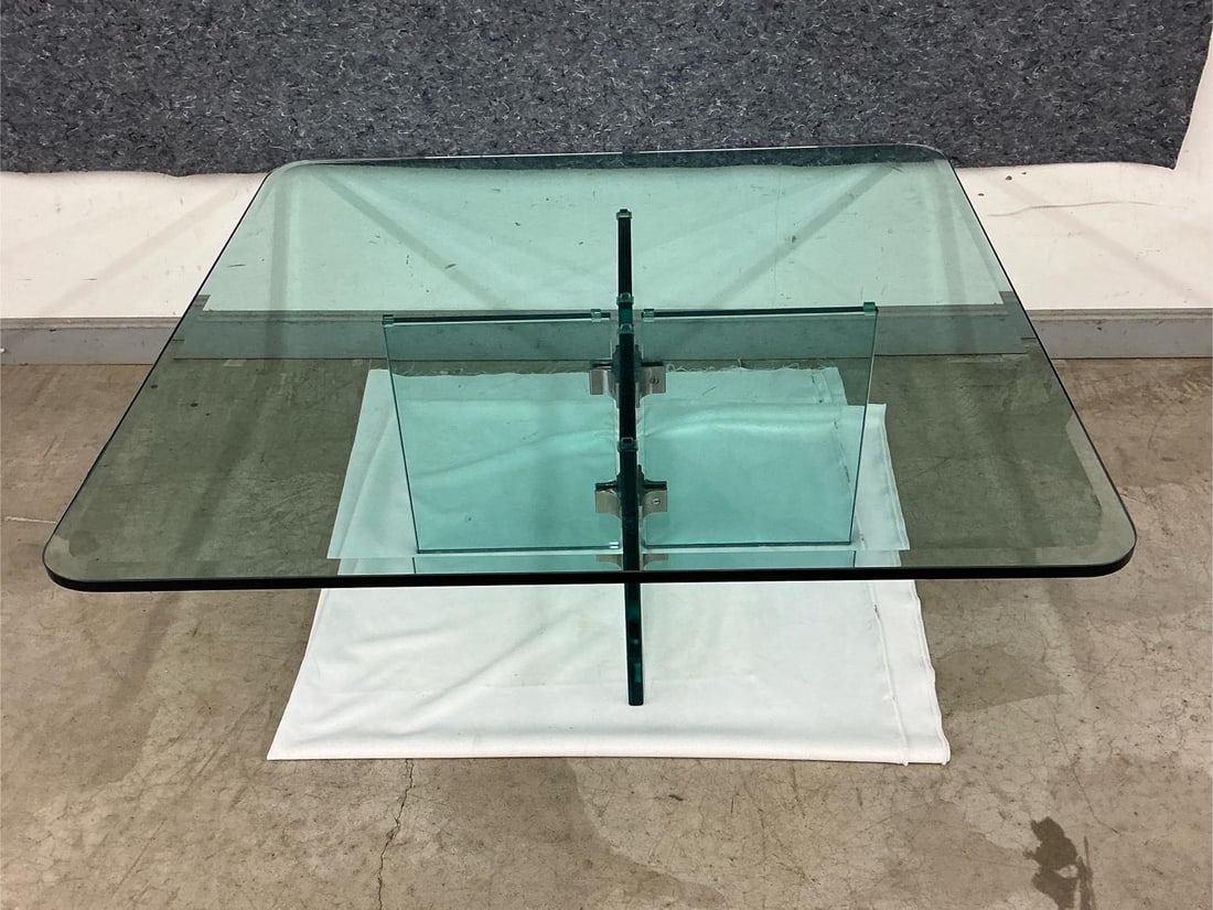 MCM Coffee Table: Vintage MCM glass coffee table with four stainless steel brackets and four glass panels supporting table top. Good condition with two extra stainless steel supports and paper directions for set up. Go