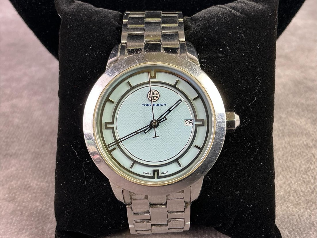 Tory Burch Watch: Tory Burch Swiss made watch featuring light blue face on silver toned hardware. In good condition. Face measures 1.5 inches in diameter.