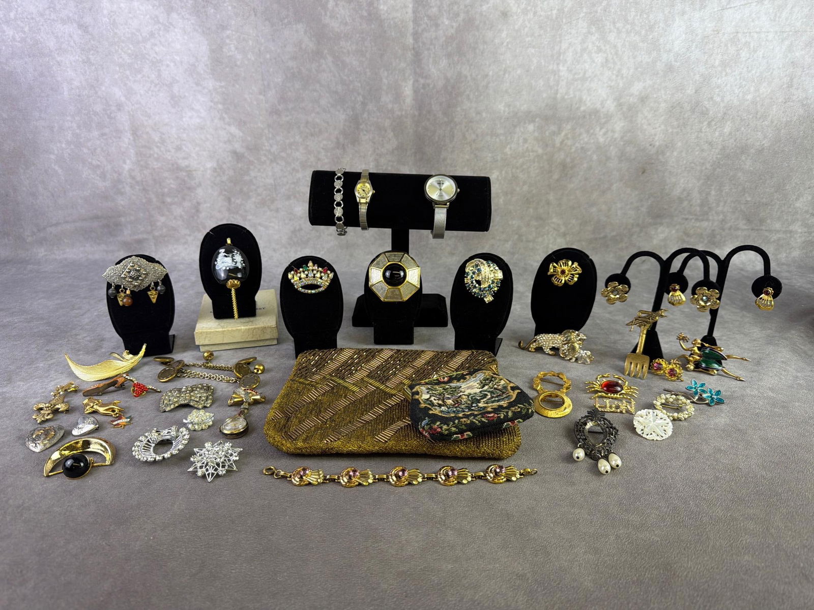 Costume Jewelry & More: Small lot of costume jewelry including brooches, two woman's watches, vintage gold colored beaded and sequined clutch, Lord Nelson Pottery perfume pendant and more. All in good condition. Bag
