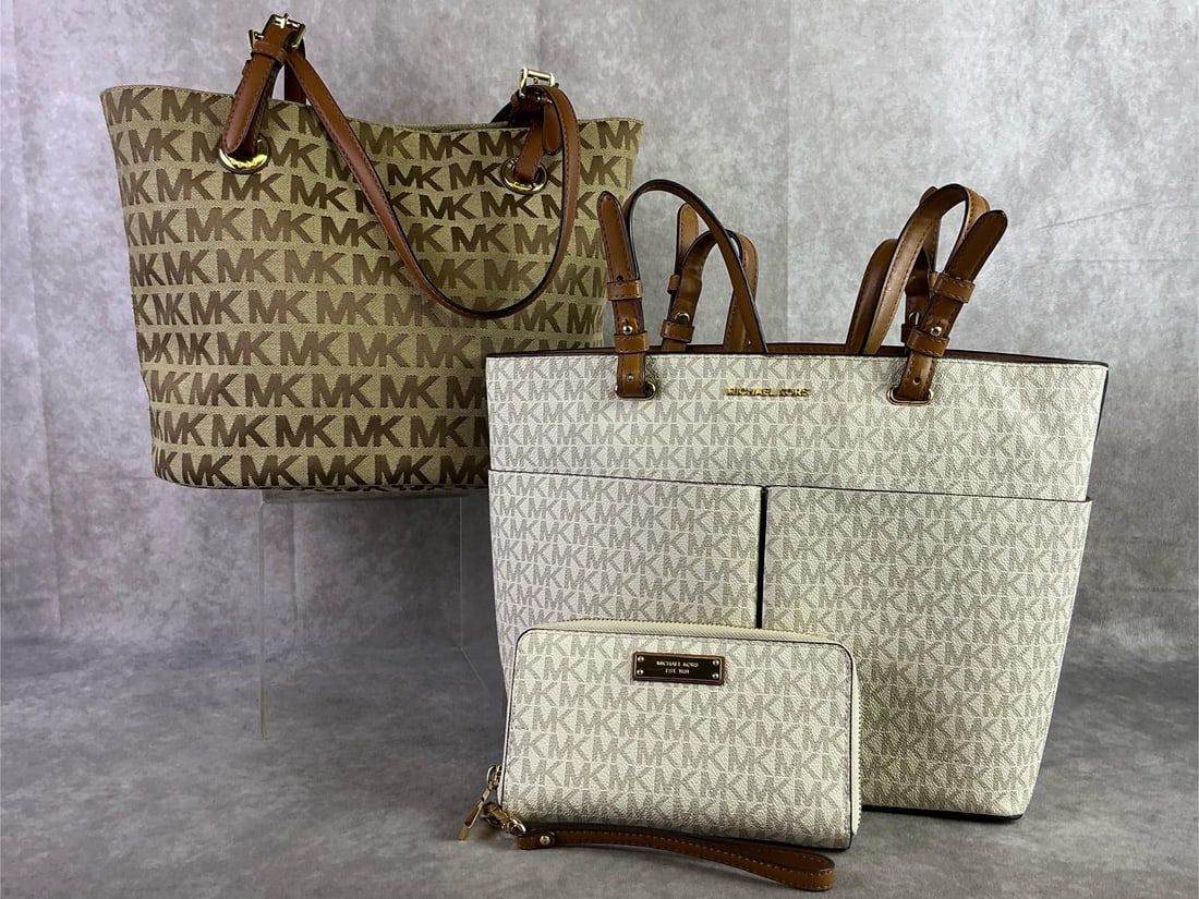 Michael Kors: Lot of two Michael Kors jet set tote bags crafted in the signature logo print. Matching wallet included with white jet set tote. All in good condition. Tote measures 12.75 inches wide x 10 inches