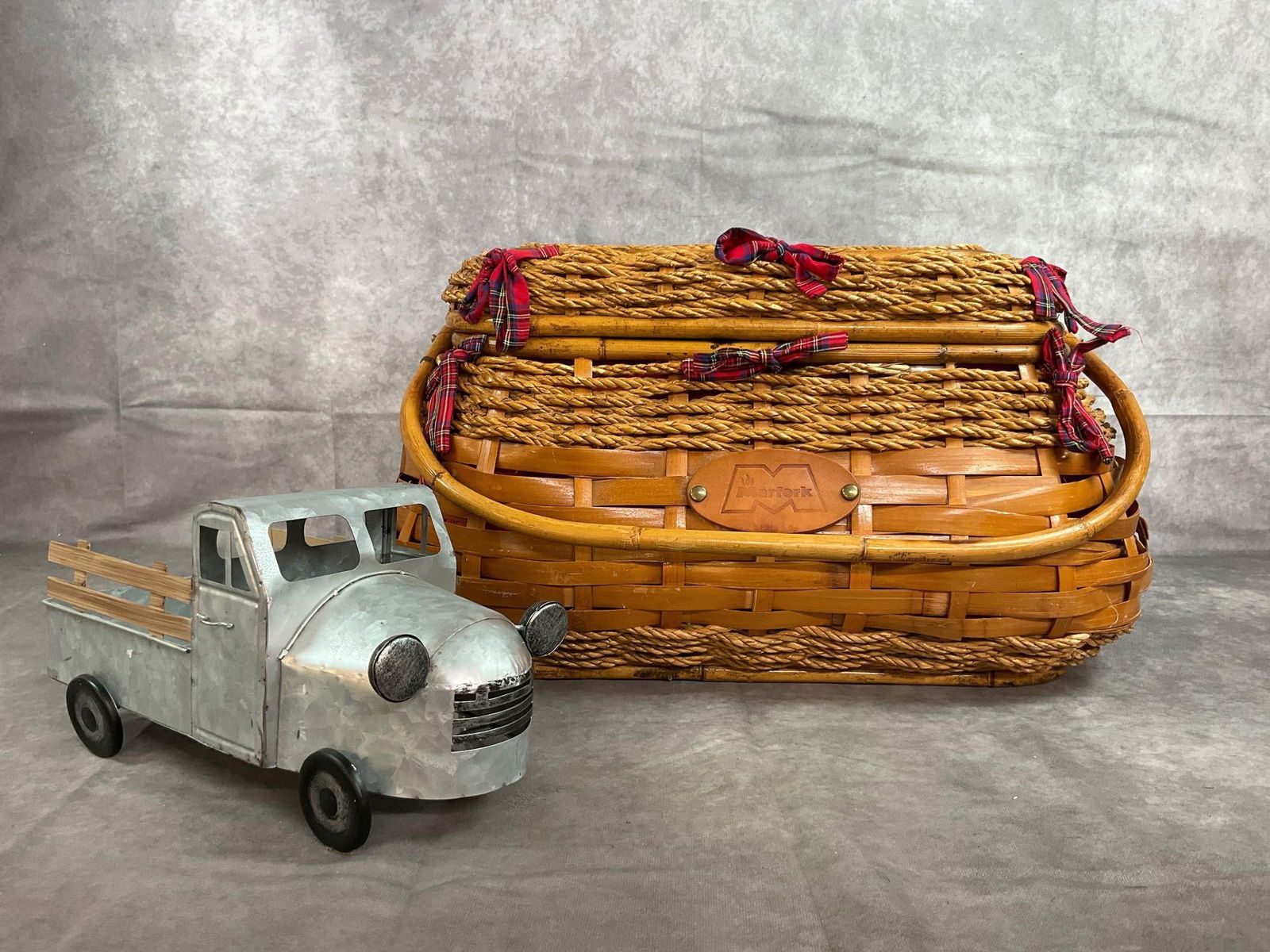 Large Picnic Basket & Metal Pick up Truck: Late century Marfork bamboo and sisal picnic basket. Lined with plaid fabric and decorated with plaid ribbons. Galvanized metal pick up truck can be used for table decor. Both in good condition.