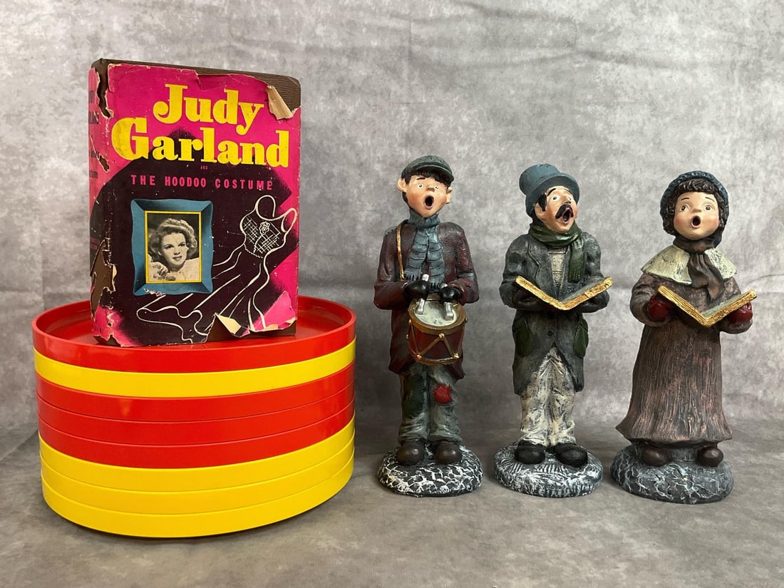Plates, Carolers, & Judy Garland Book: Twelve mid century items. Heller 10" stacking plates in yellow and orange. Three Windsor Collection Carolers hand painted figurines, and a Judy Garland and the Hoodoo Costume 1945 novel. Book has