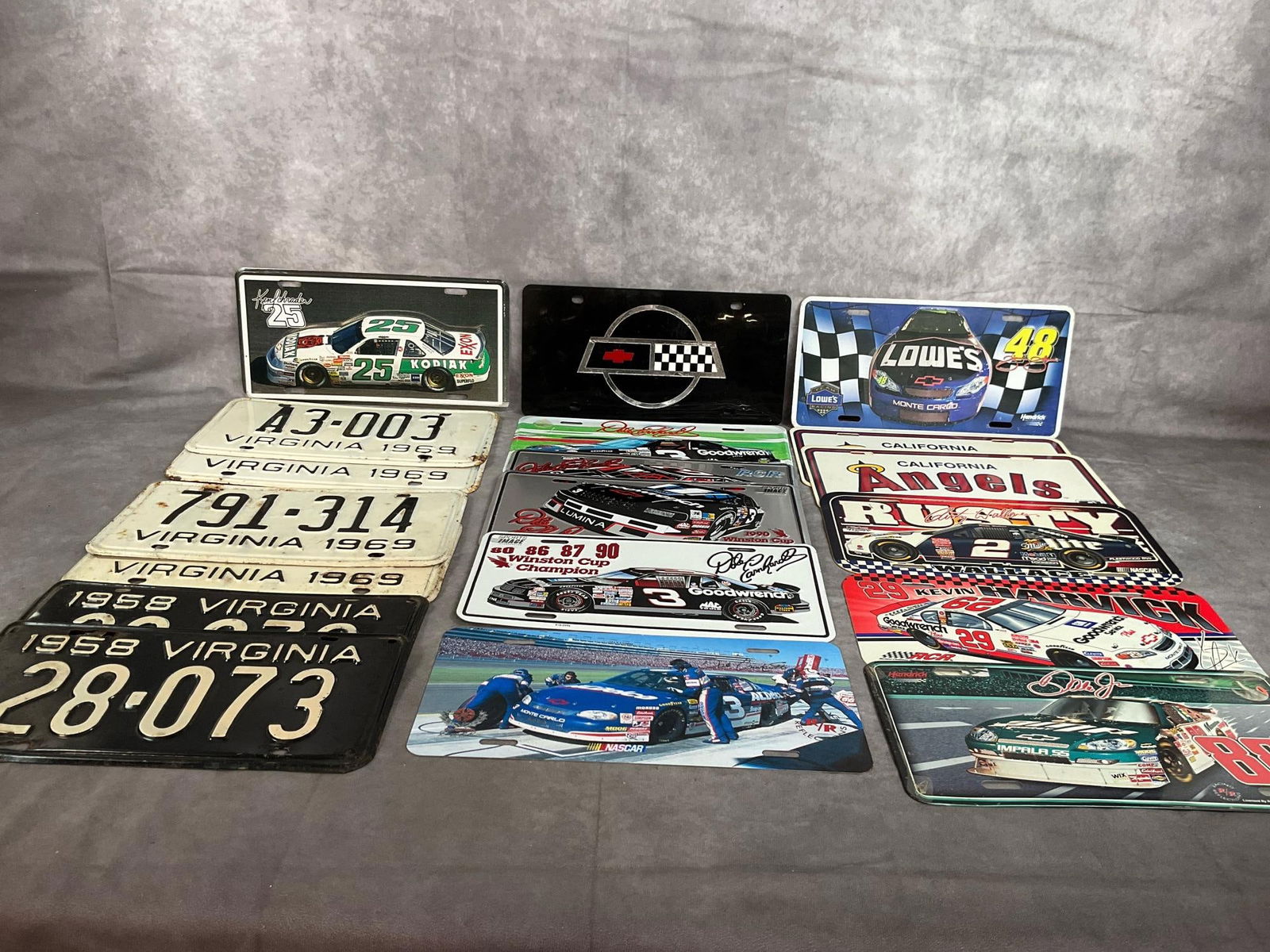 License Plates: Nineteen 1958 to late century license plates. Includes Virginia plates from 1958 and 1969, five Dale Earnhardt tags, California Angels plates, as well as various race car drivers. Plates made of