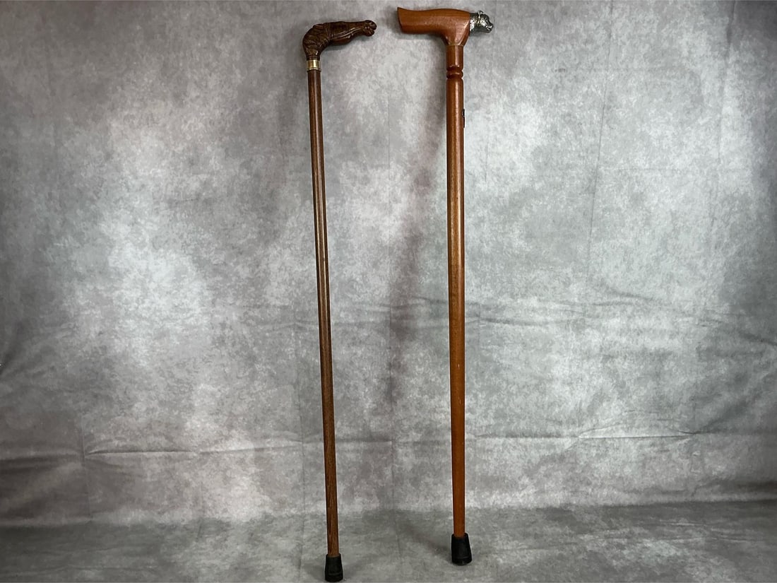 Walking Sticks: Two late 20th century wooden walking sticks. One South African walking stick with a pewter cheetah head and a pewter map of Africa attached to the shaft with Makoulpa marked on the cane. One walking