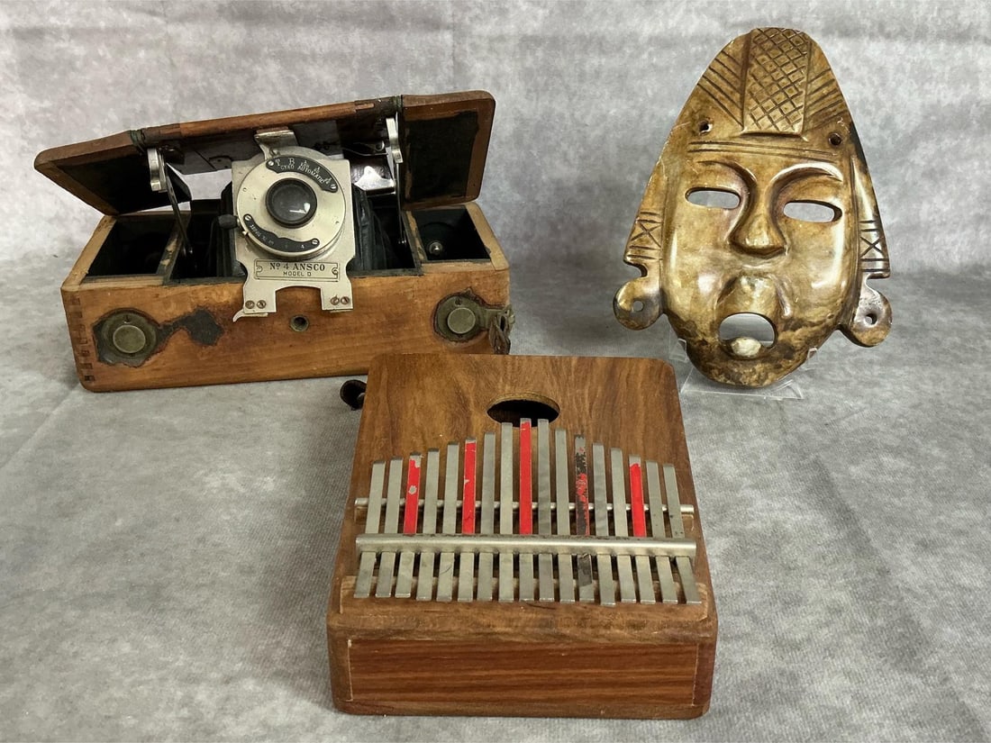 Mask, Camera, & Kalimba: Three late 1800s to mid 1900s items. Kalimba wooden instrument made in South Africa, and decorative mask carved from stone. Includes Ansco model D camera in wood box. Camera is untested and in fair