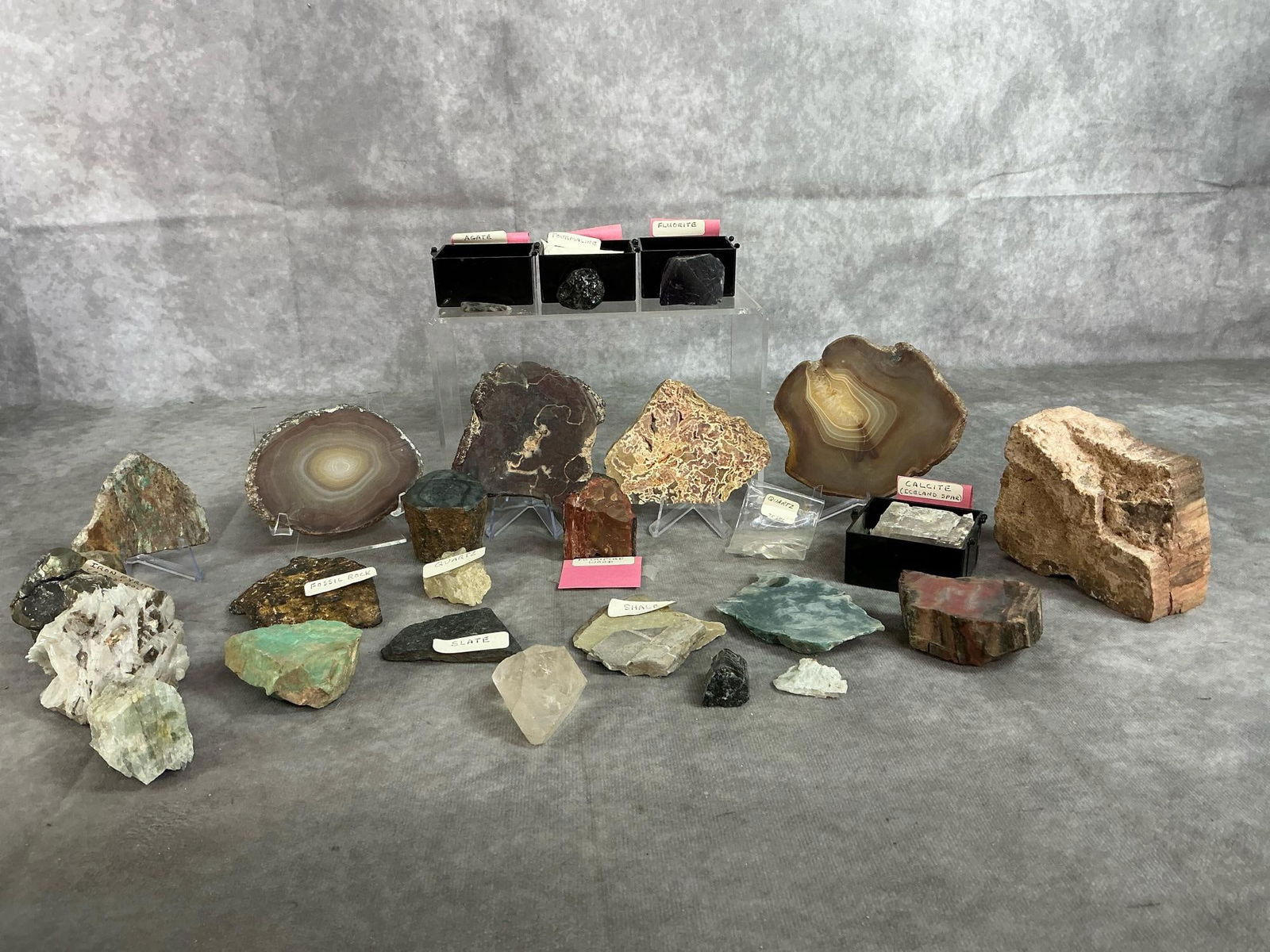Rock Collection: Twenty five rocks and minerals. Includes shale, iron pyrite, quartz, tourmaline, turquoise, jadeite, fluorite and fossils. Includes shale good condition. Largest quartz slab measures 3.75 inches x