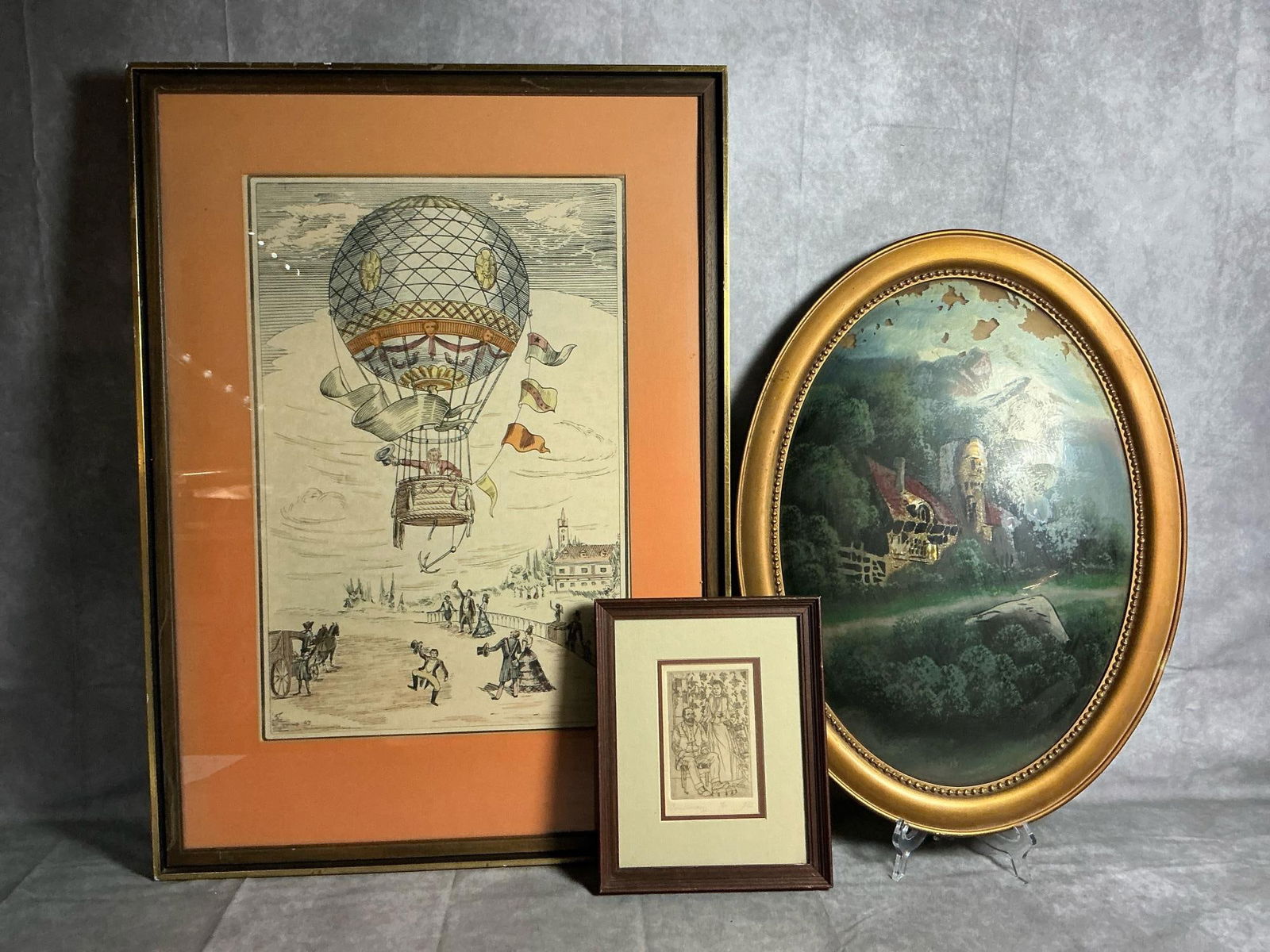 Early Art Trio: Three early 1900s art pieces. Oval bubble picture with painting done on back of glass, in ornate frame. Balloon Ride is a hand colored etching by Franco Rainaldi, and small etching titled