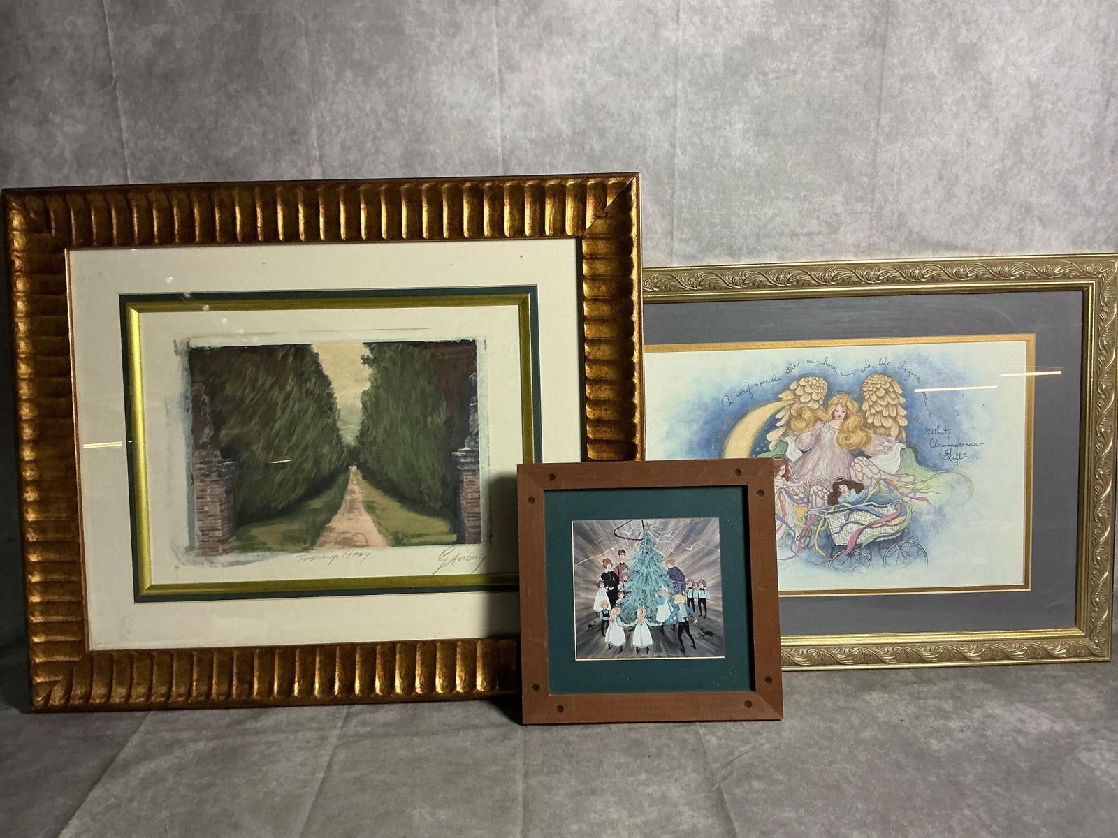 P Buckley Moss, the Little Star, and Tuscany Prints: Three late 1900s prints. "A Family Christmas" by P Buckley Moss, "That Little Star" with Angels around Baby print, and ornate gold toned frame titled Tuscany, Italy by GAnong. All in good condition.