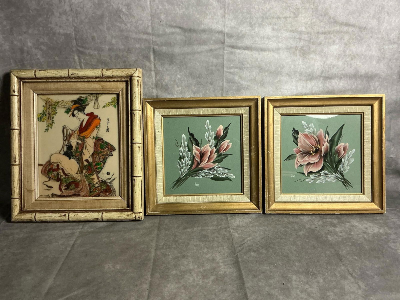 Geisha Engraving & Floral Prints: Three mid century art pieces. Geisha by Edris on framed etched tile. Two floral prints with green background and gold toned wood frame. Frames are nicked and have scratches. Geisha measures 12 inches