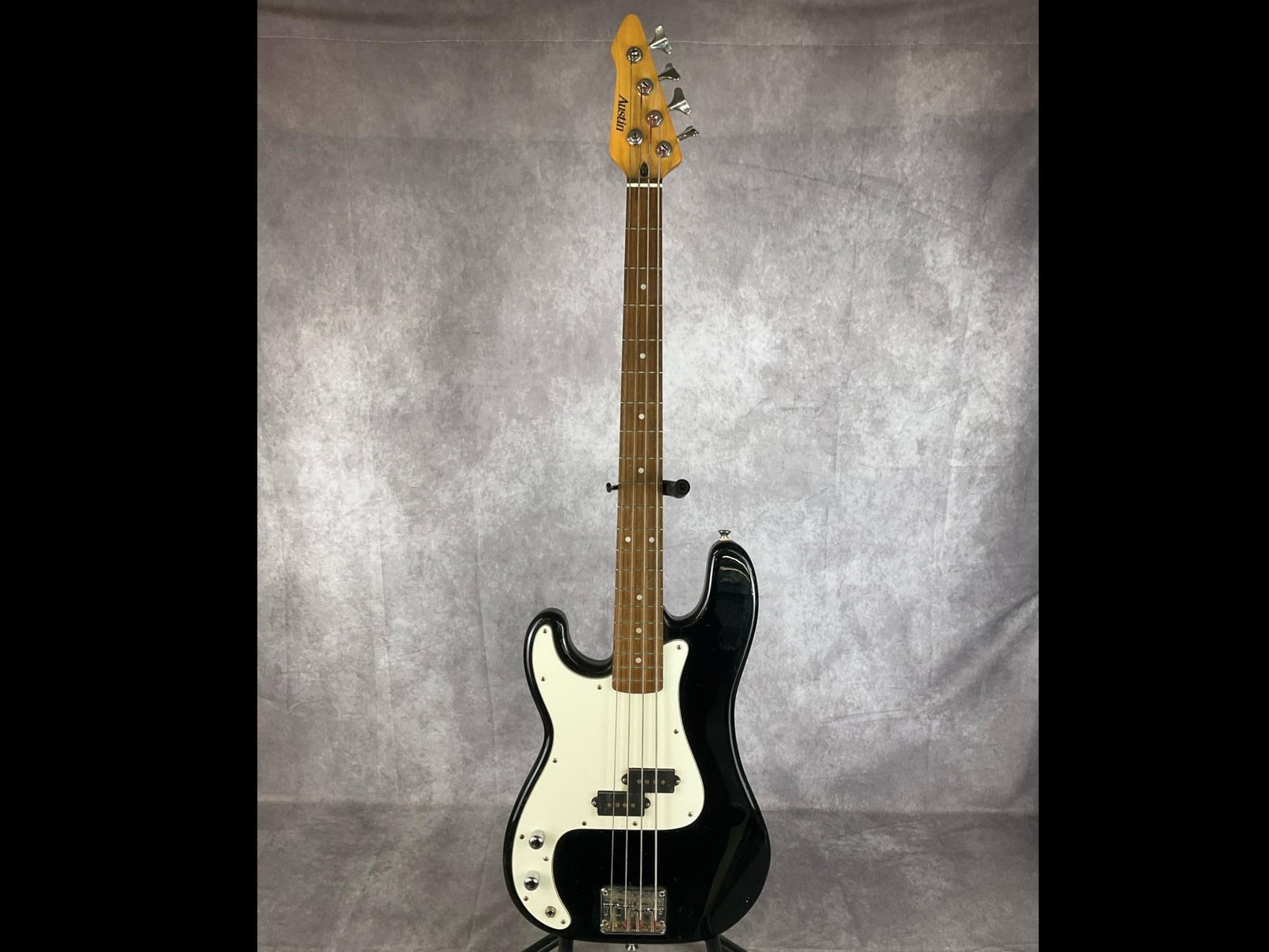 Austin Four String Bass: Austin precision bass body black gloss finish with white pick guard left handed four string bass. Chrome clover leaf style machine head tuners, two volume/tone knobs, split single coil pickups, vintag