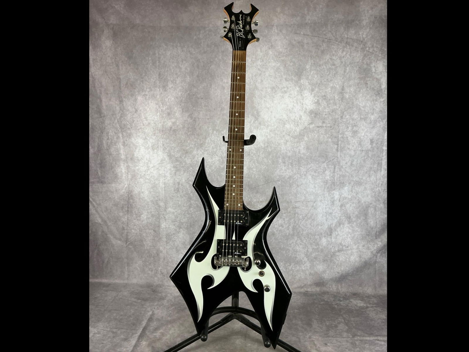 B.C. Rich Warlock Bronze Series Electric Guitar: B.C. Rich bronze series warlock body from basswood or agathis in black finish with white tribal accents six string electric guitar. Widow headstock, two volume/tone knobs, three way selector switch. S
