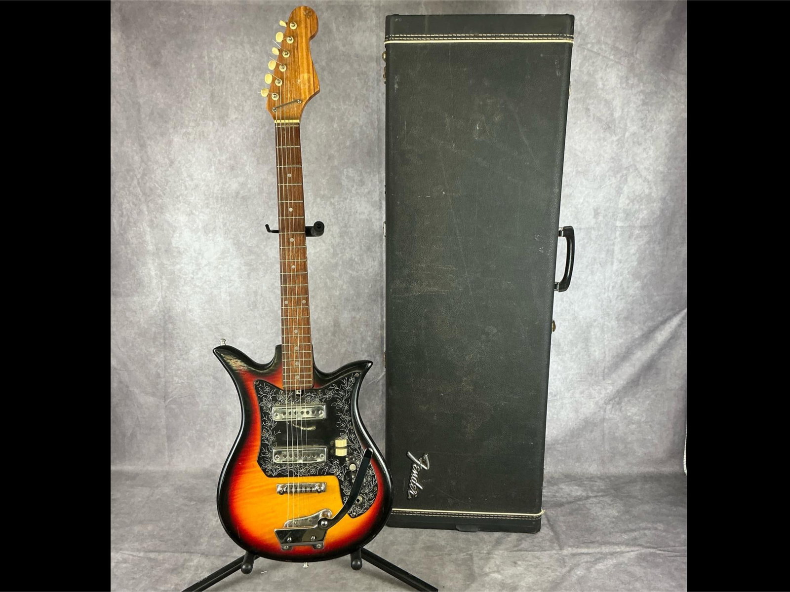 Vintage ET-210 Electric Guitar: Unbranded vintage et210 tulip style body in three tone sunburst finish with black pick guard with white floral accents six string electric guitar. Two volume/tone knobs, open gear machine tuners, two