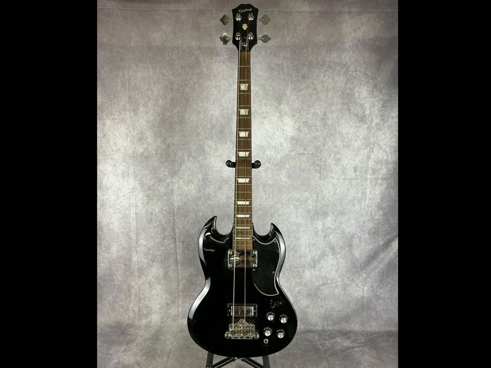 Epiphone SG Electric Bass: Epiphone sg style body from mahogany in black finish with black pick guard four string electric bass. Four volume knobs, three way selector switch, two humbucker pickups. Serial number UC08040035. Bri