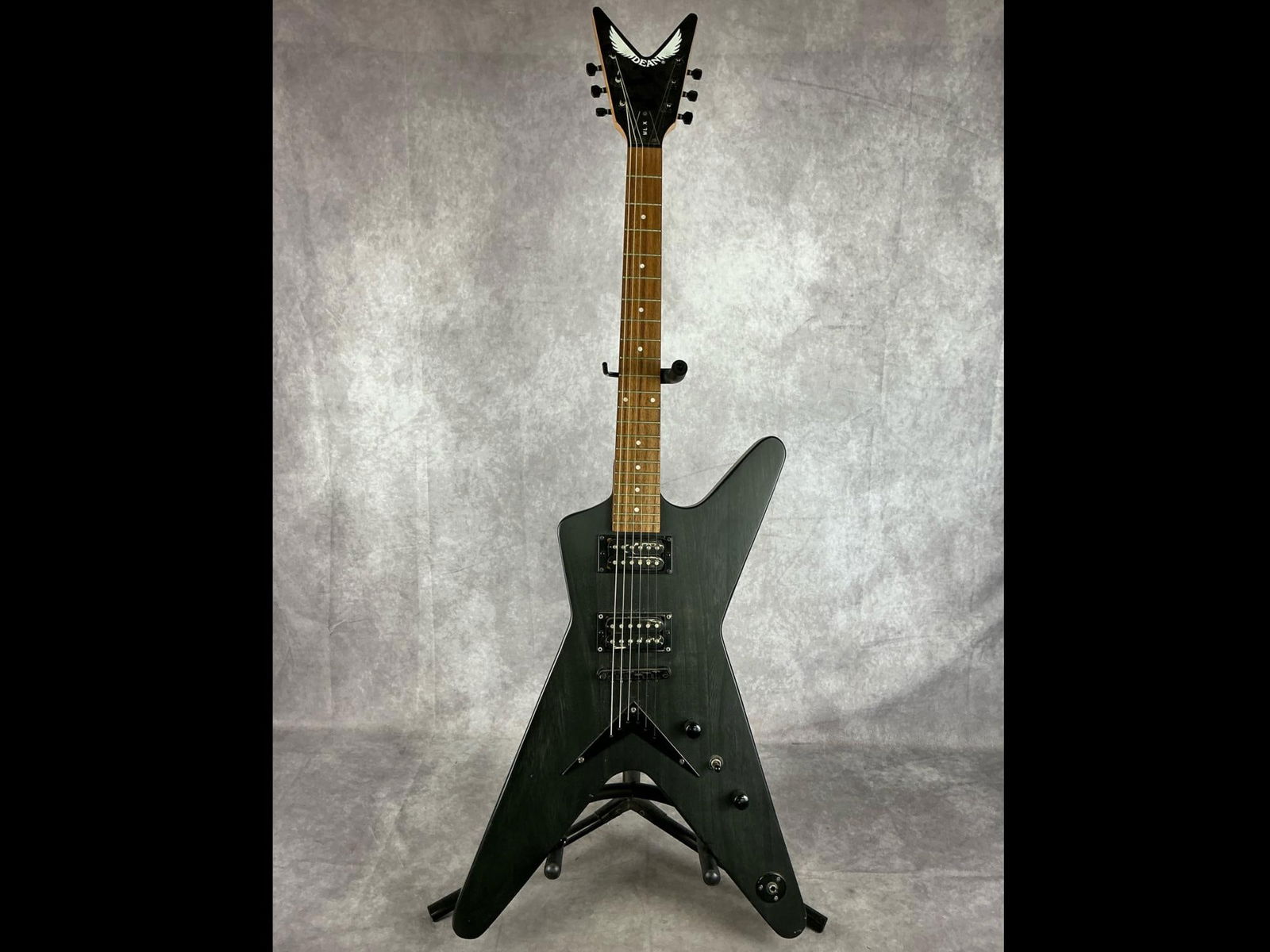 Dean ML-X Electric Guitar: Dean ML style body from paulownia in trans black finish six string electric guitar. Two volume/tone knobs, three way selector switch, bridge and neck pickups. Serial number O10111439. Bridge, neck,