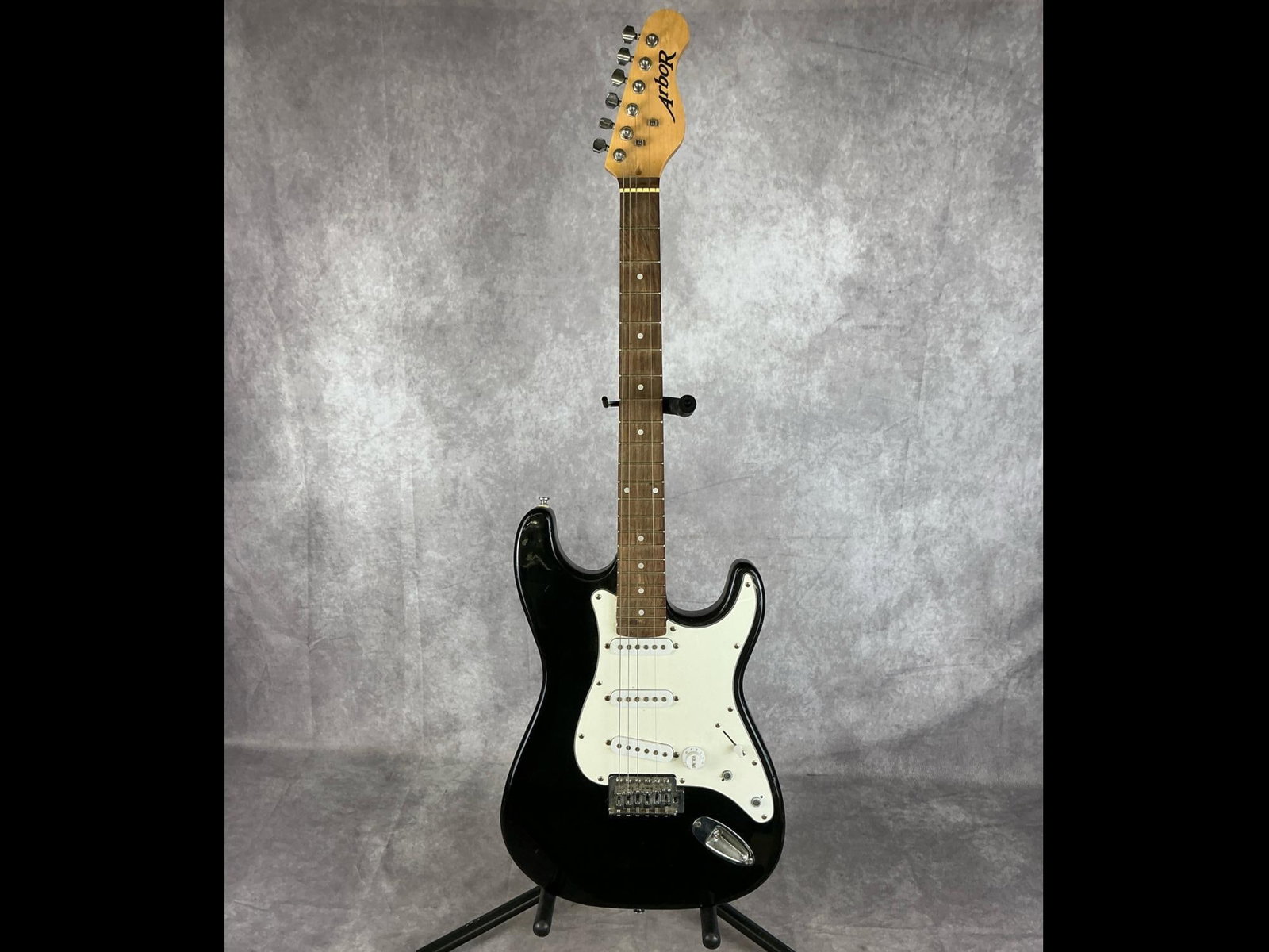 Arbor Stratocaster Electric Guitar: Arbor Stratocaster body from alder in black finish with white pick guard six string electric guitar. Three volume/tone knobs, five way selector switch, three sss pickups. No visible serial number.