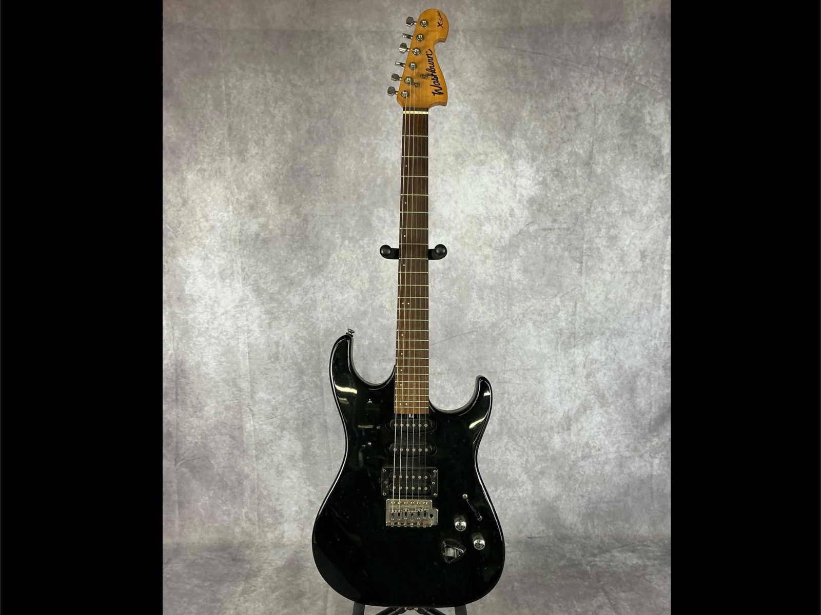Washburn X-Series Electric Guitar: Washburn x series double cutaway solid body from basswood in black gloss finish six string electric guitar. Two volume/tone knobs, five way selector switch, HSS pickup configuration, pick holder. Seri